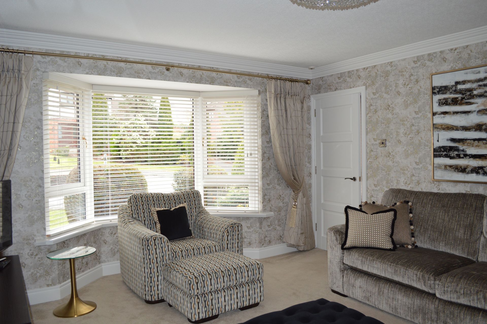 A living room with a couch , chair and ottoman.