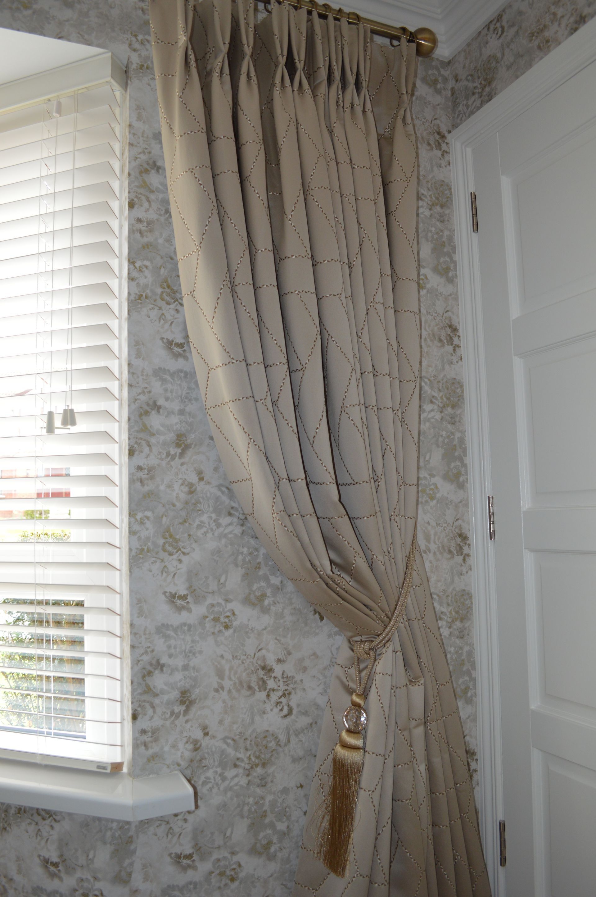 A pair of curtains hanging on a window next to a door.