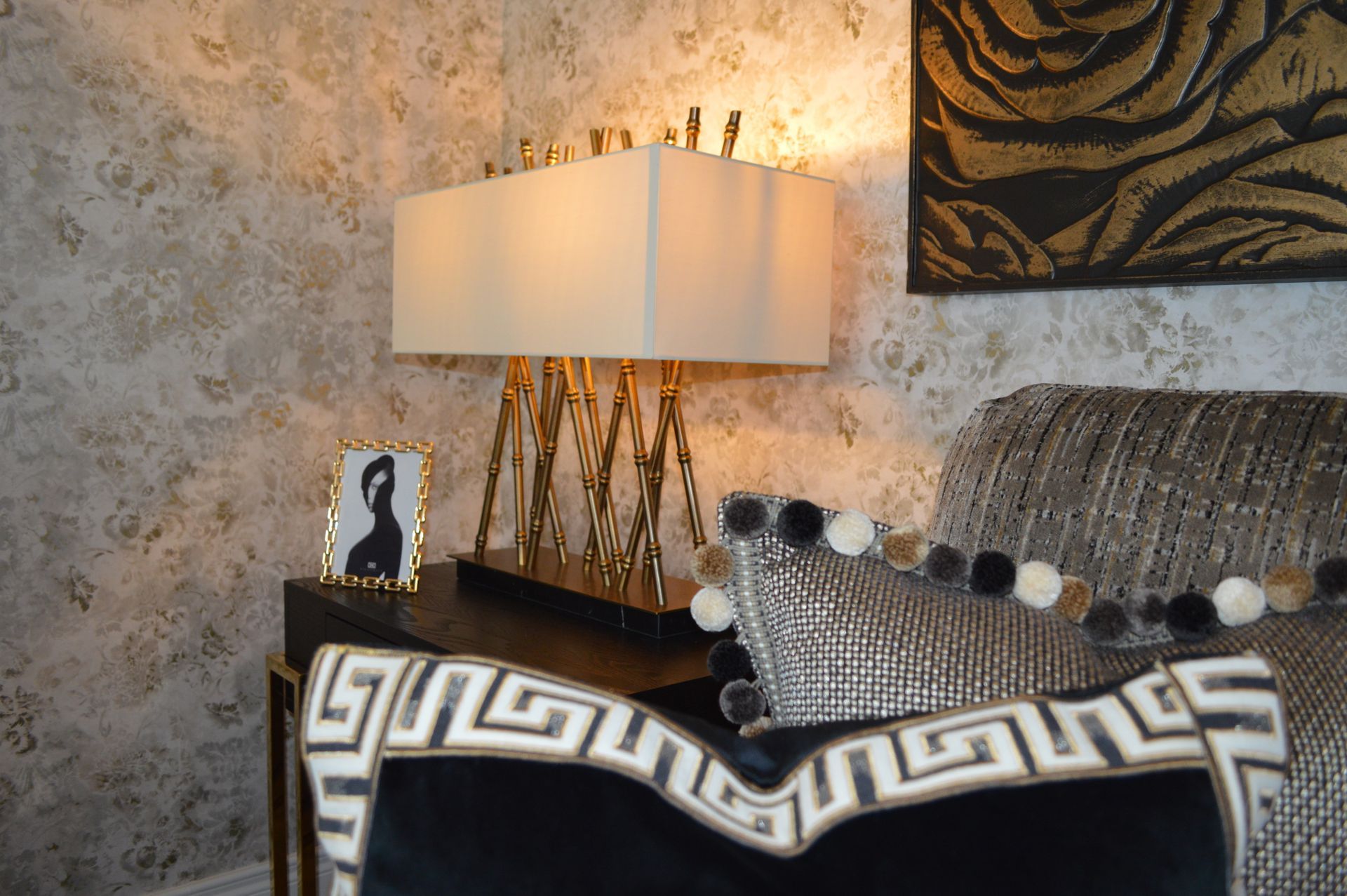 A living room with a couch a lamp and a picture on the wall