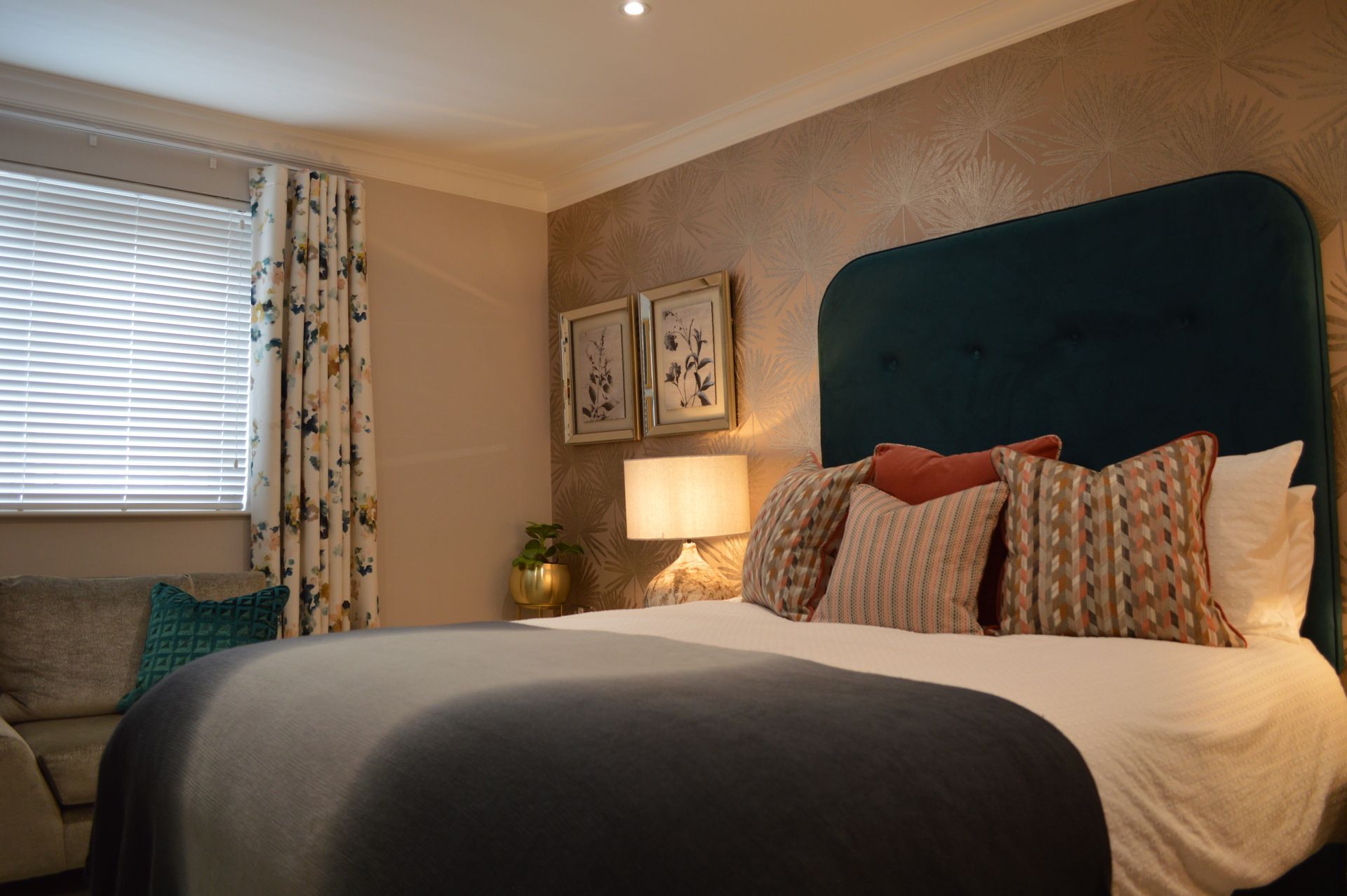 A bedroom with a bed , chair , lamp and window.