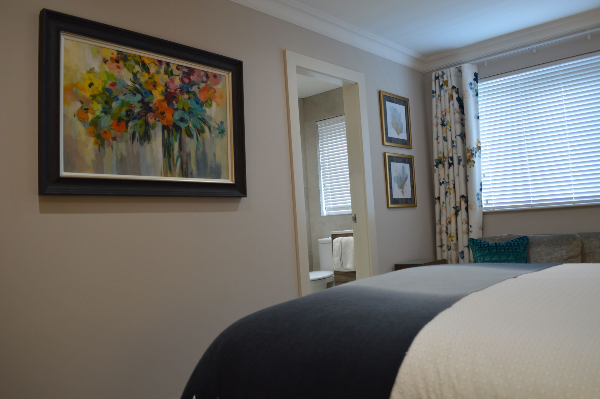 There is a painting on the wall above the bed in the bedroom.