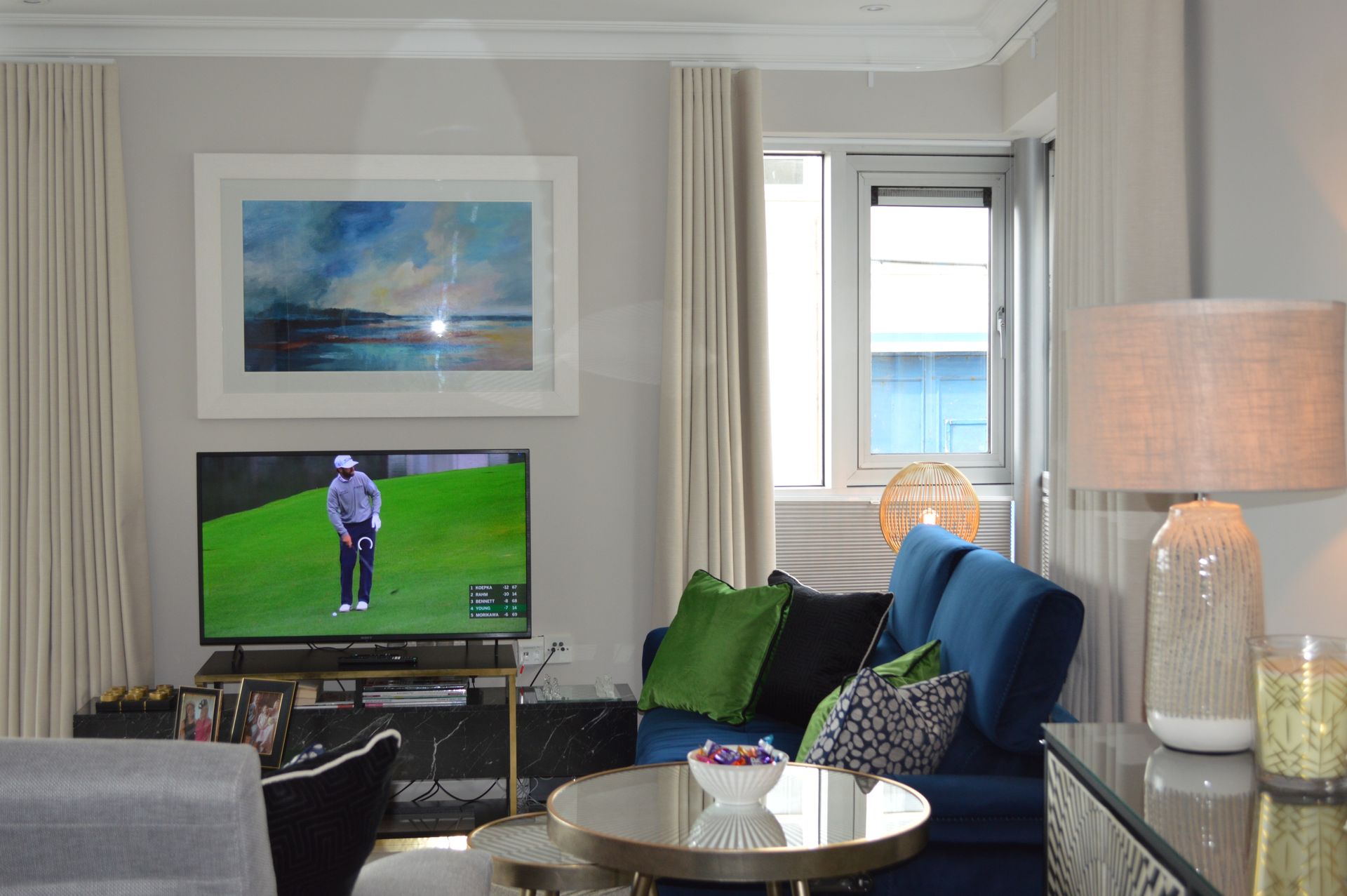 A living room with a blue couch and a flat screen tv