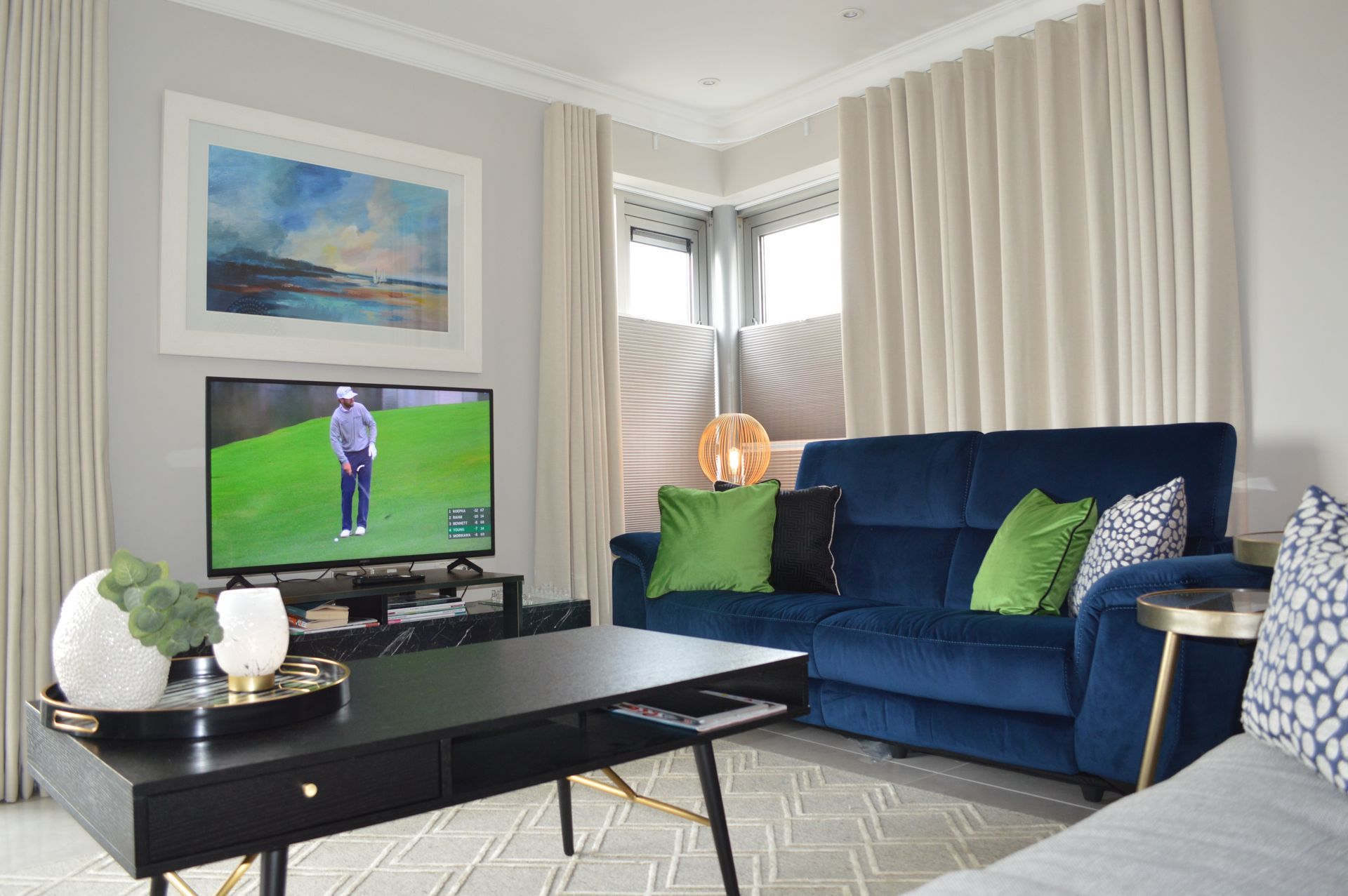 A living room with a blue couch and a flat screen tv.