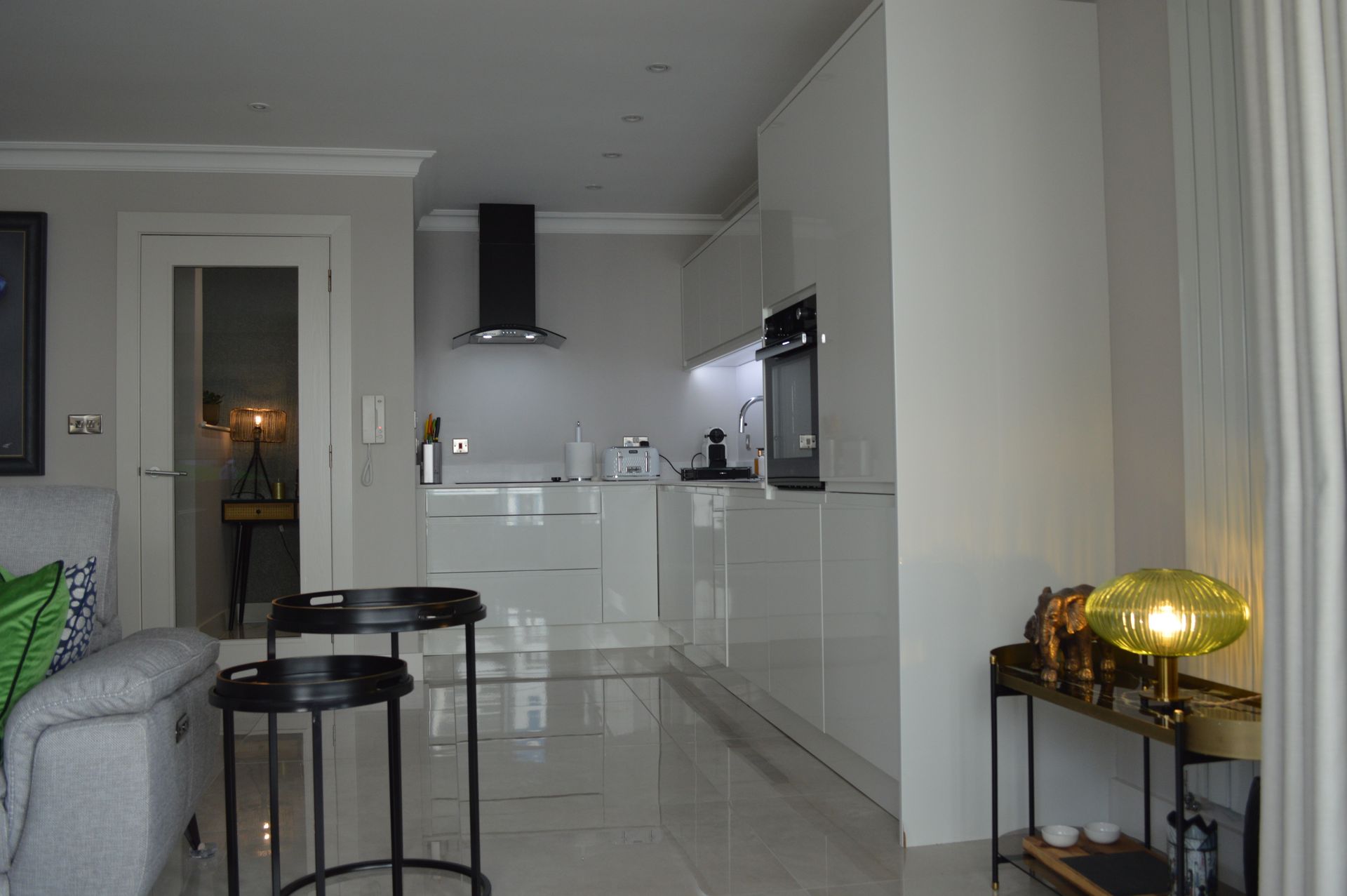 A living room with a couch and a table and a kitchen in the background.