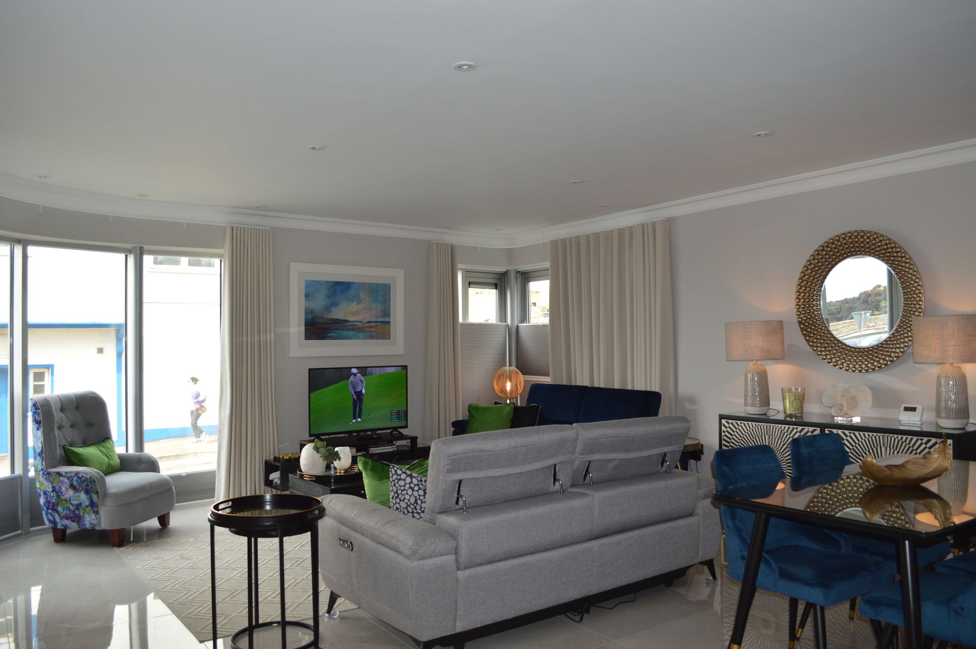 A living room with a couch , chairs , a table and a television.