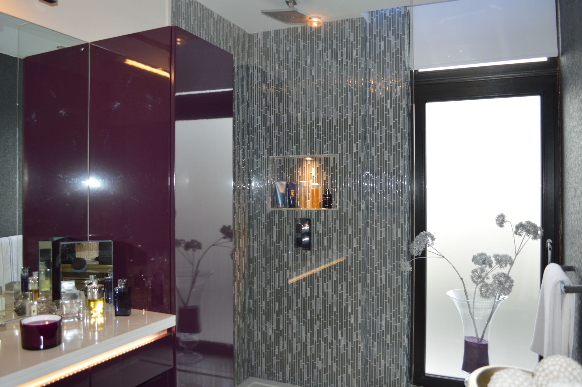 A bathroom with purple cabinets and a walk in shower
