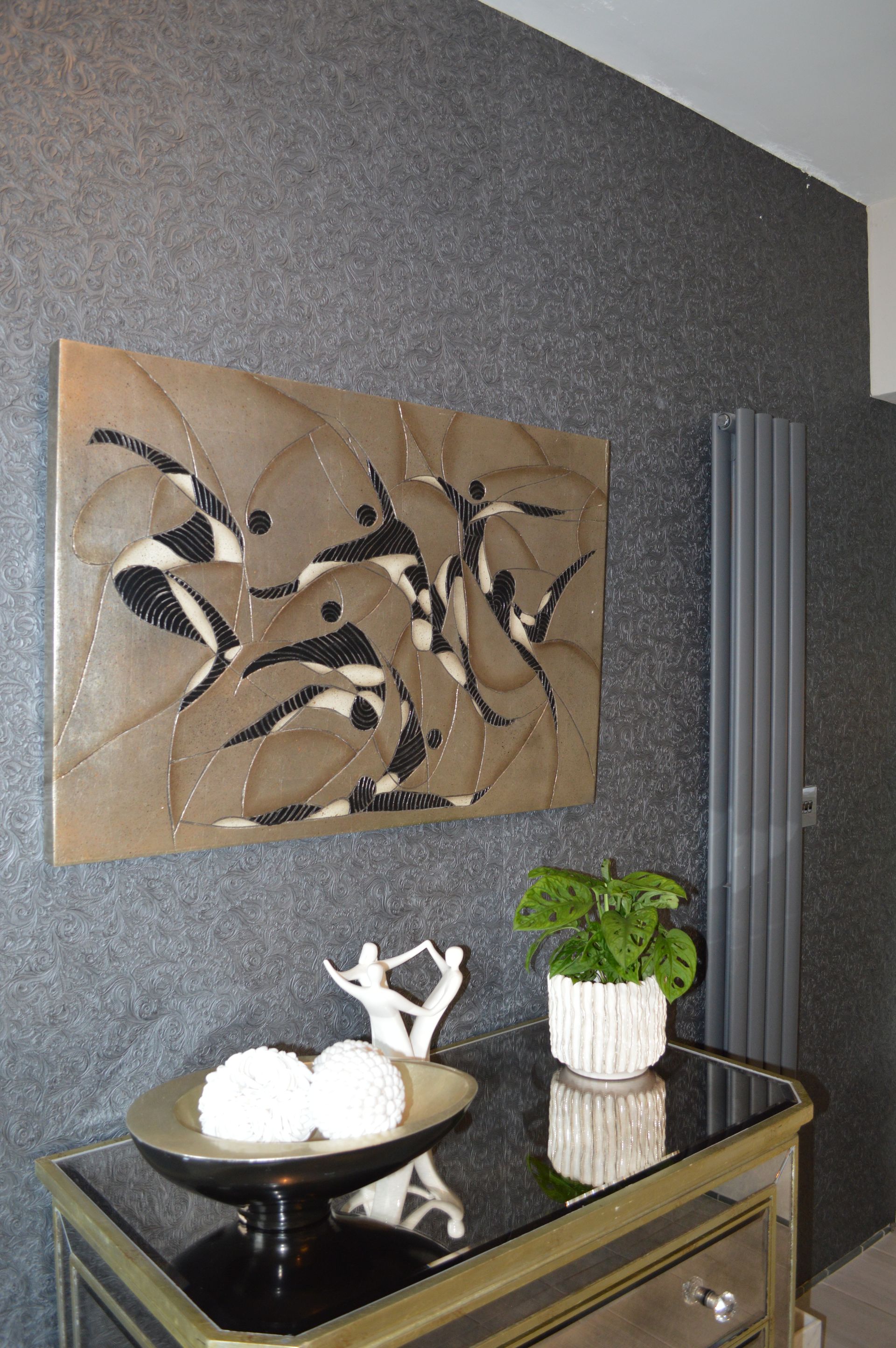 A painting is hanging on a wall above a table.