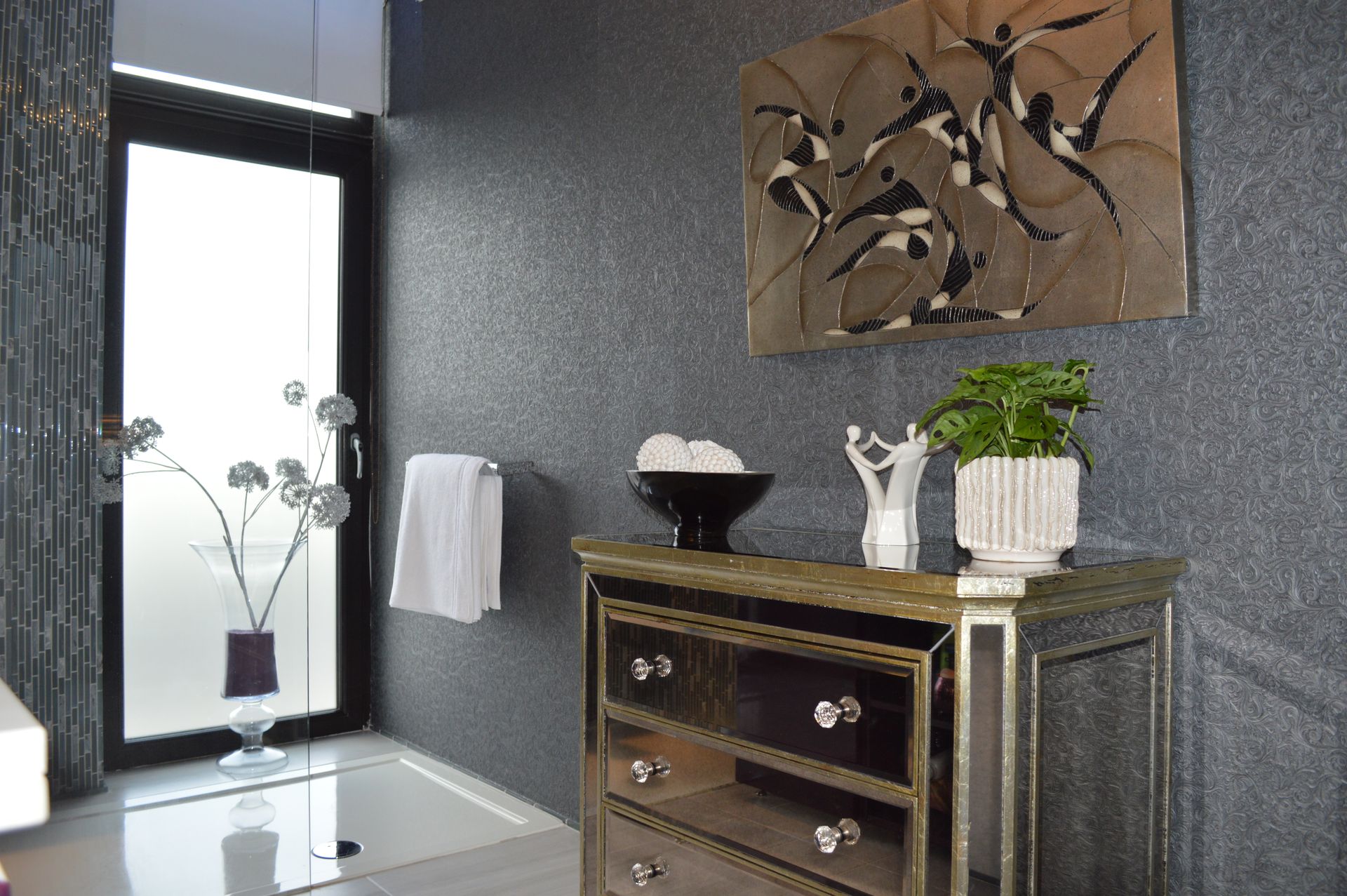 A bathroom with a dresser and a painting on the wall