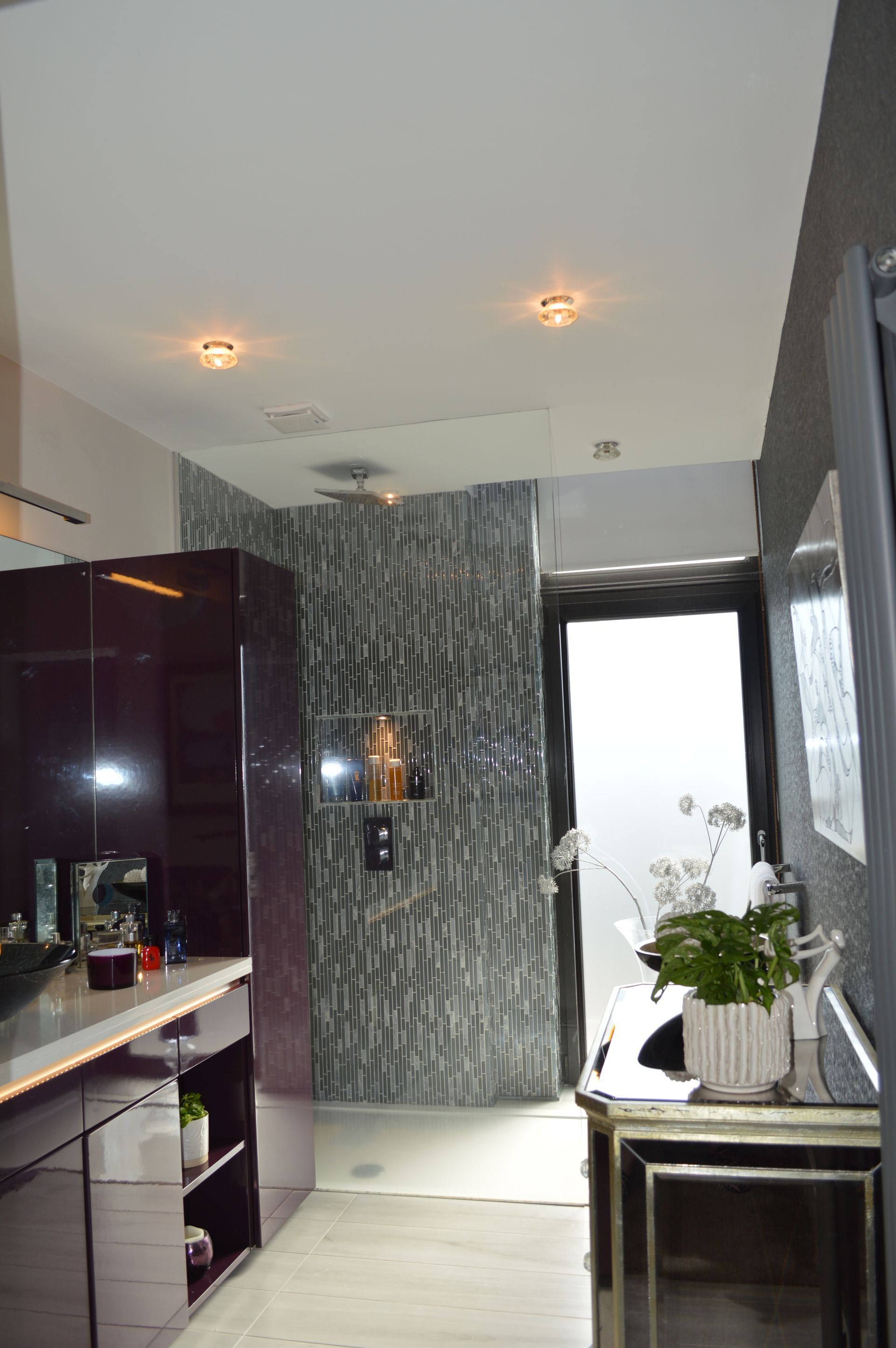 A kitchen with purple cabinets and a marble wall