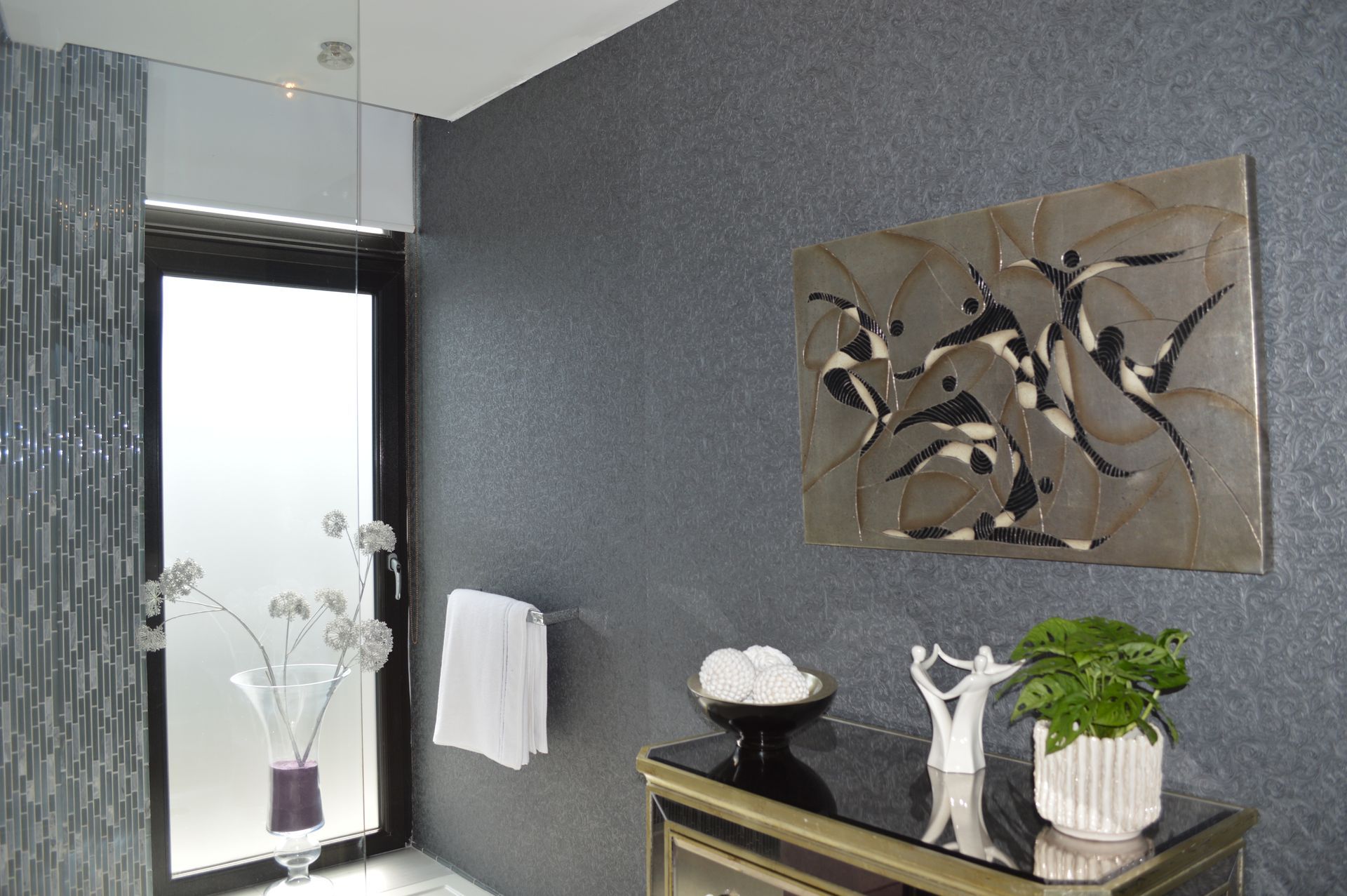 A bathroom with a painting on the wall above the door