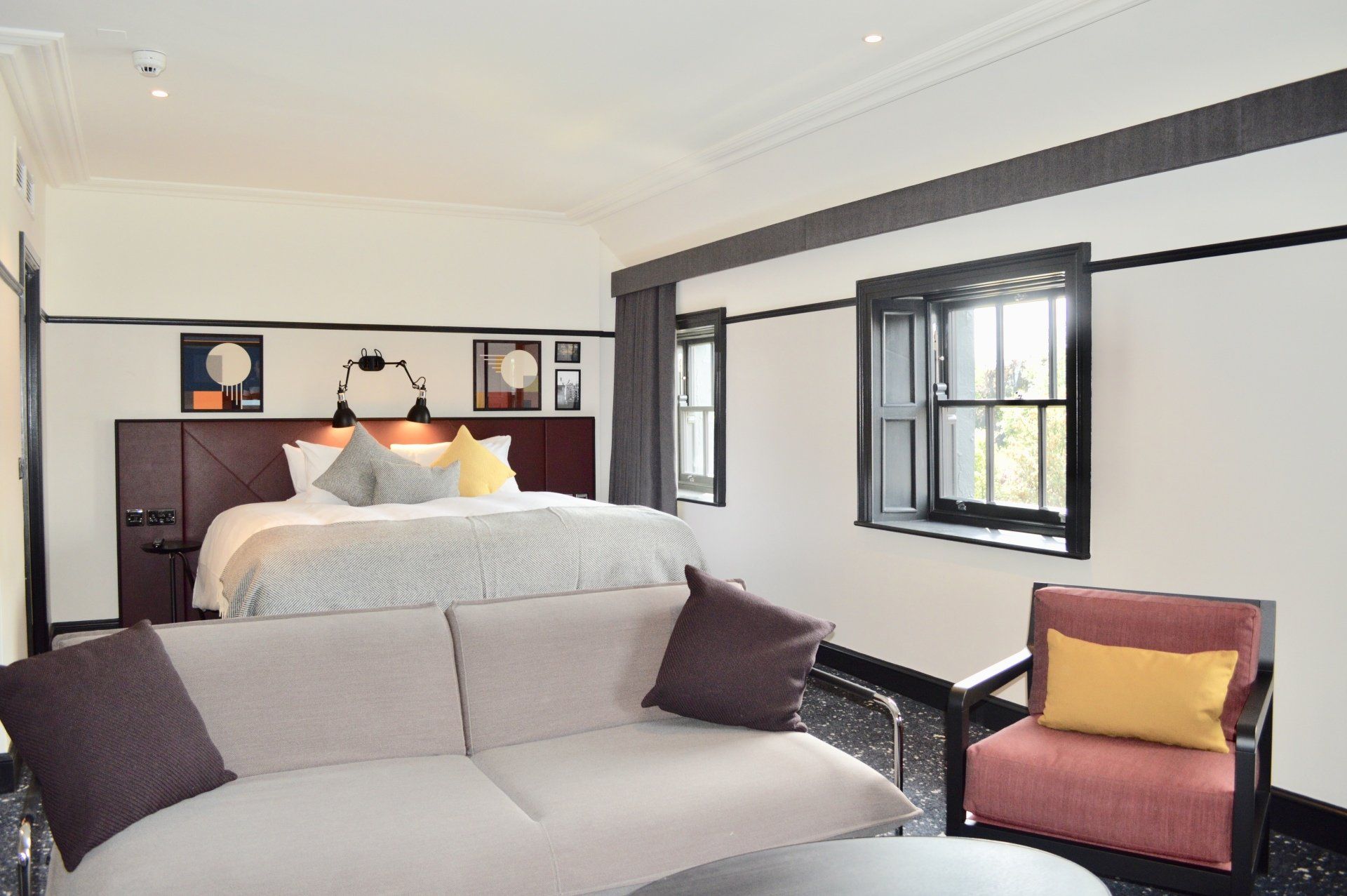 A hotel room with a bed , couch , chair and table.