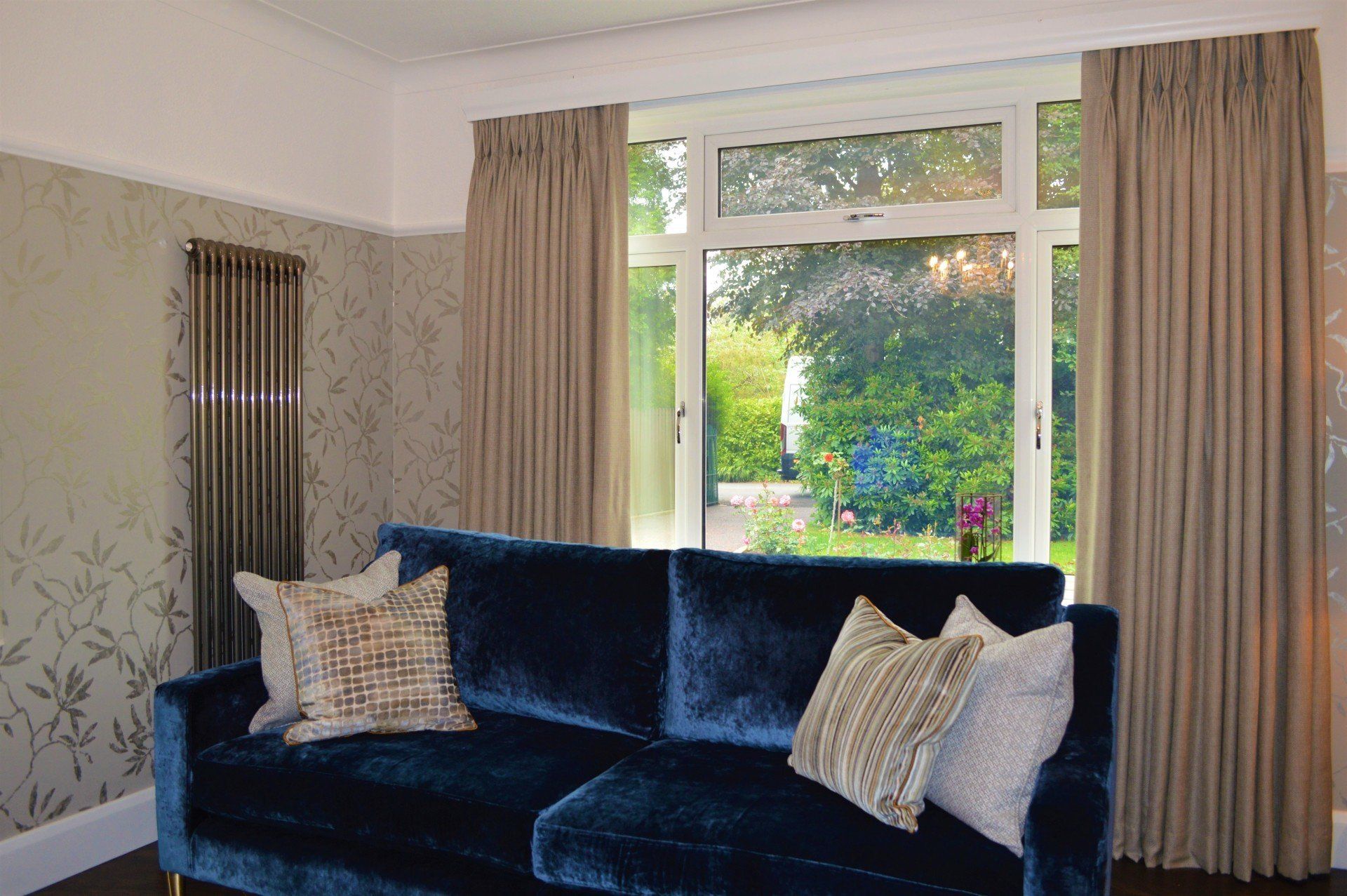 A living room with a blue couch and a large window.