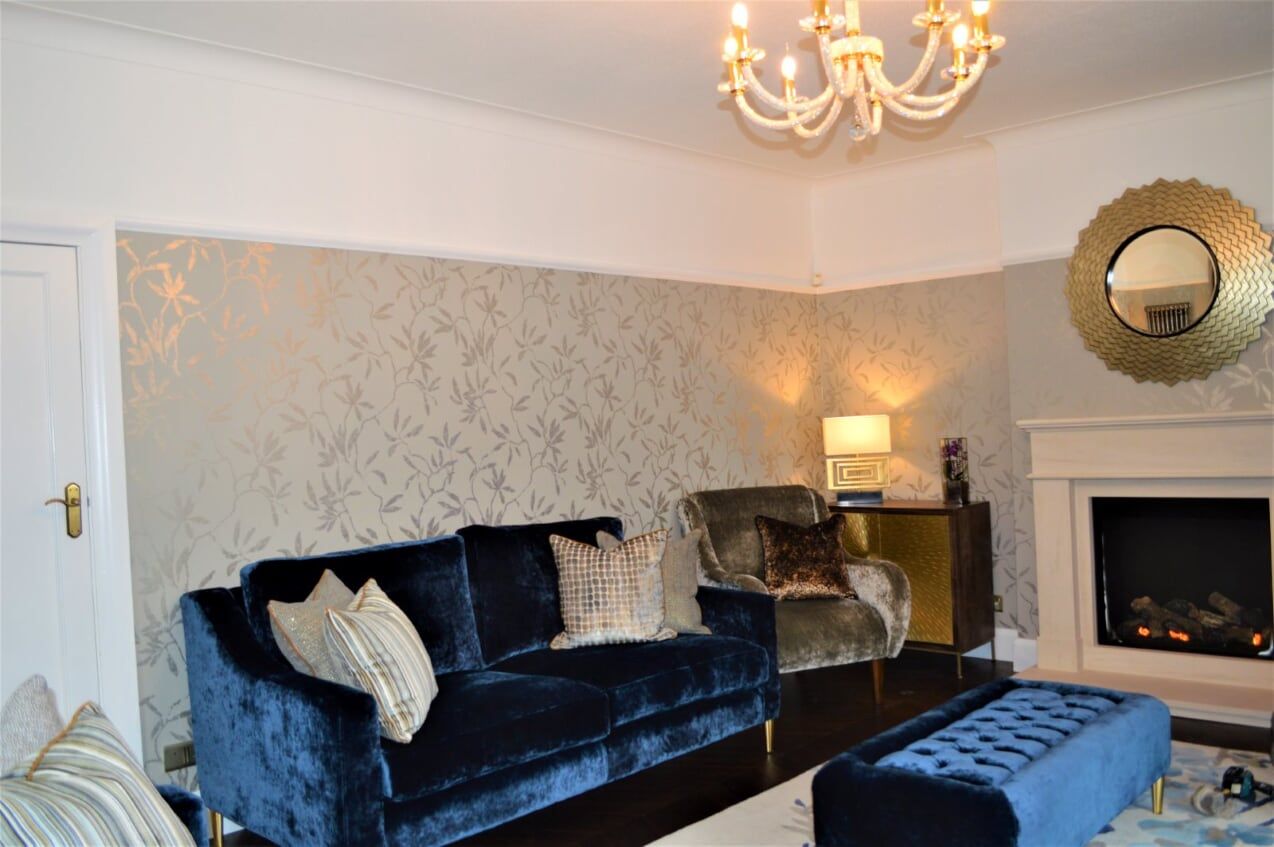 A living room with a blue couch and a fireplace