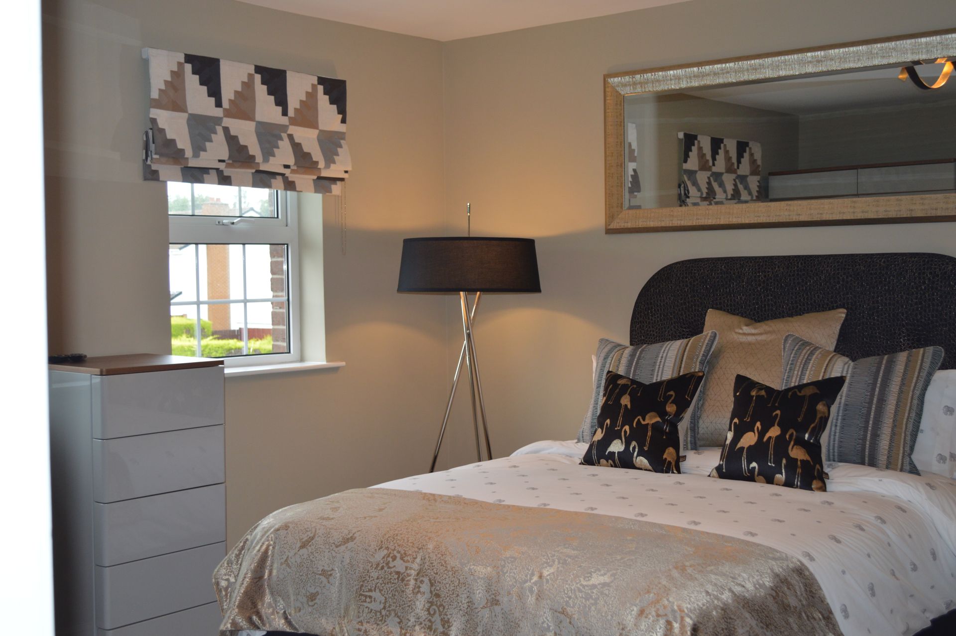 A bedroom with a large bed and a mirror