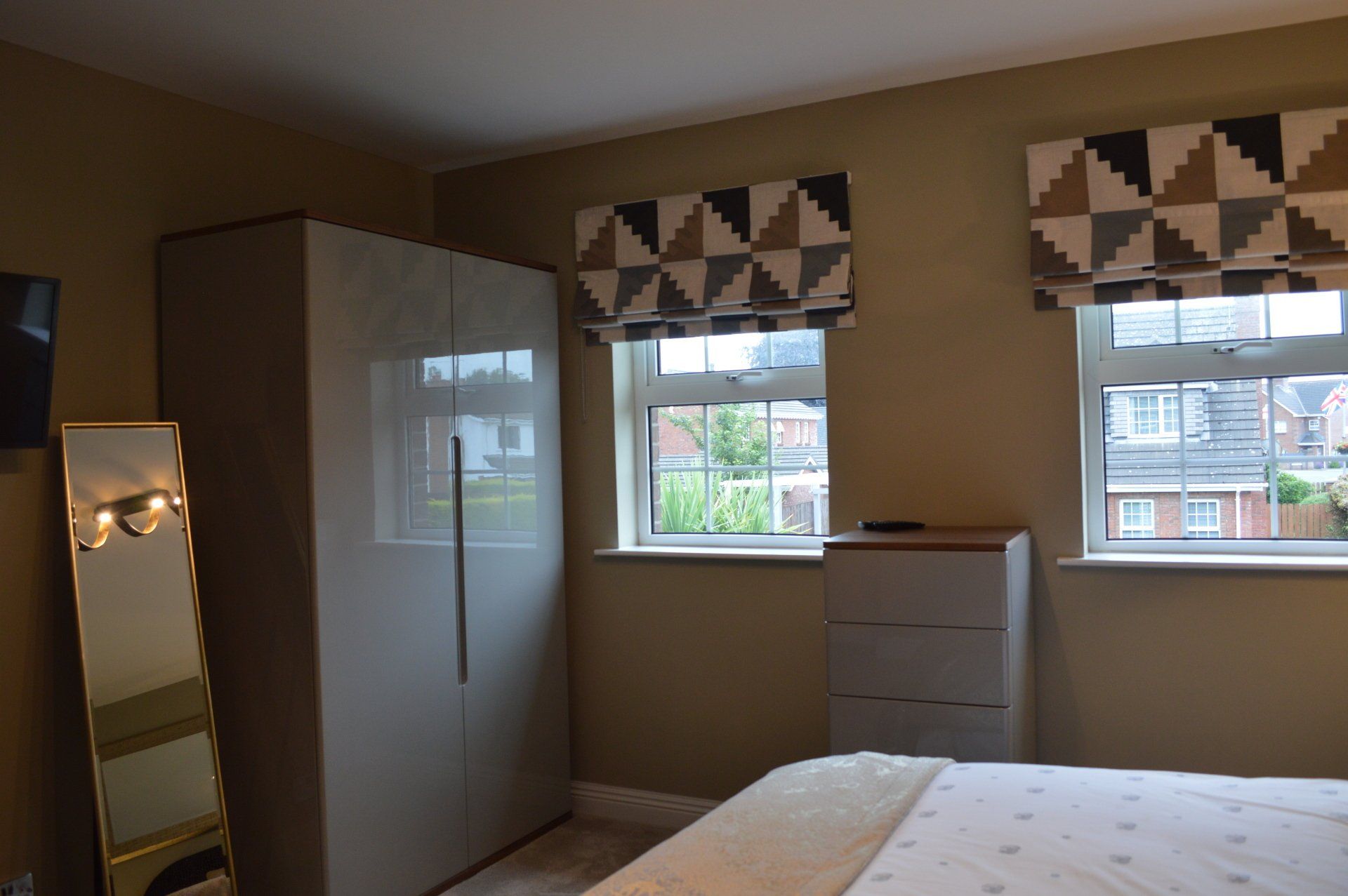 A bedroom with a bed a mirror and a wardrobe