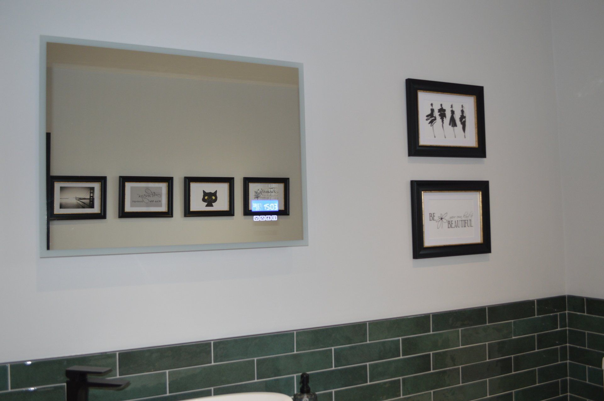 A bathroom with green tiles and a mirror