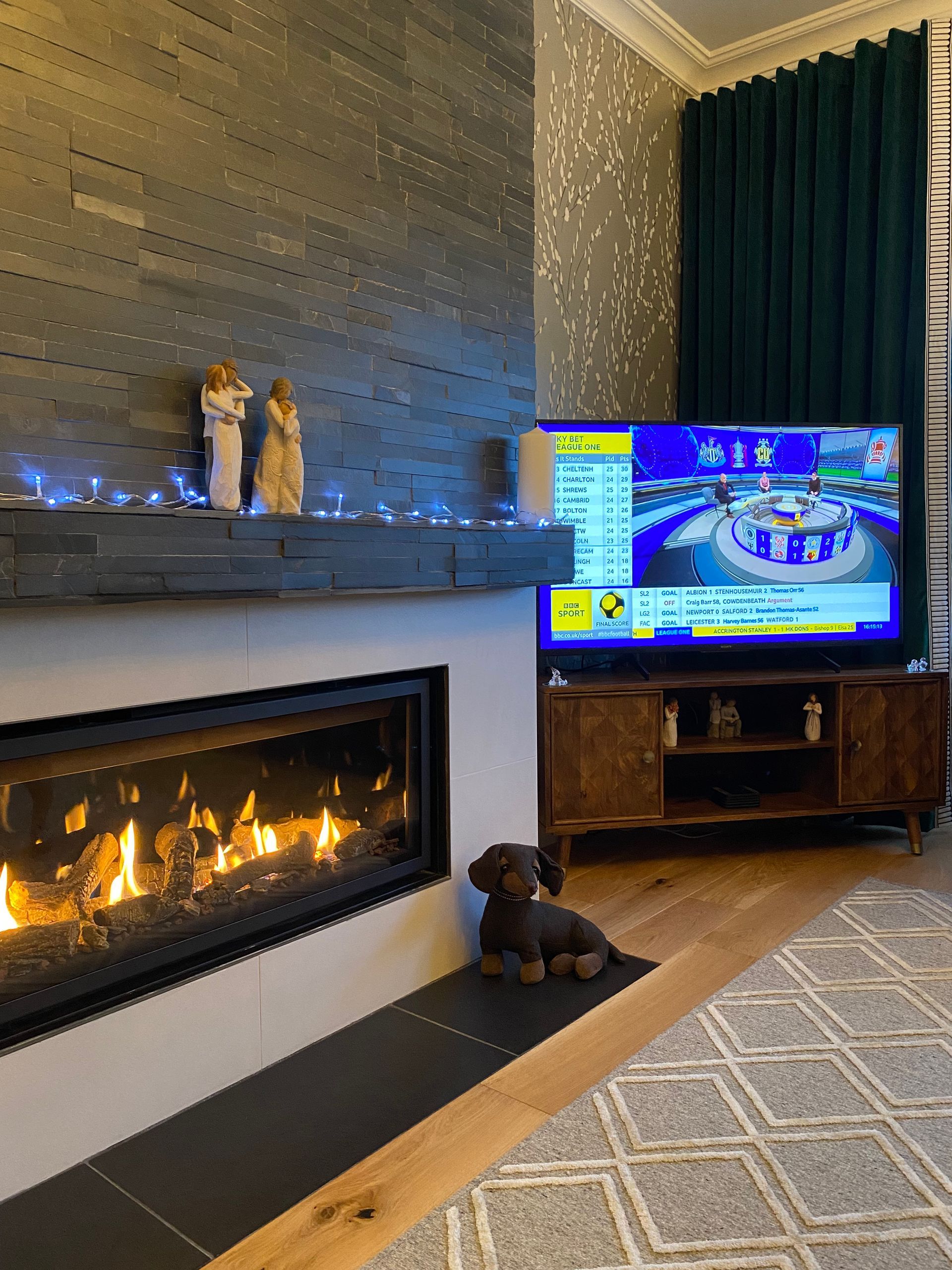 A living room with a fireplace and a flat screen tv