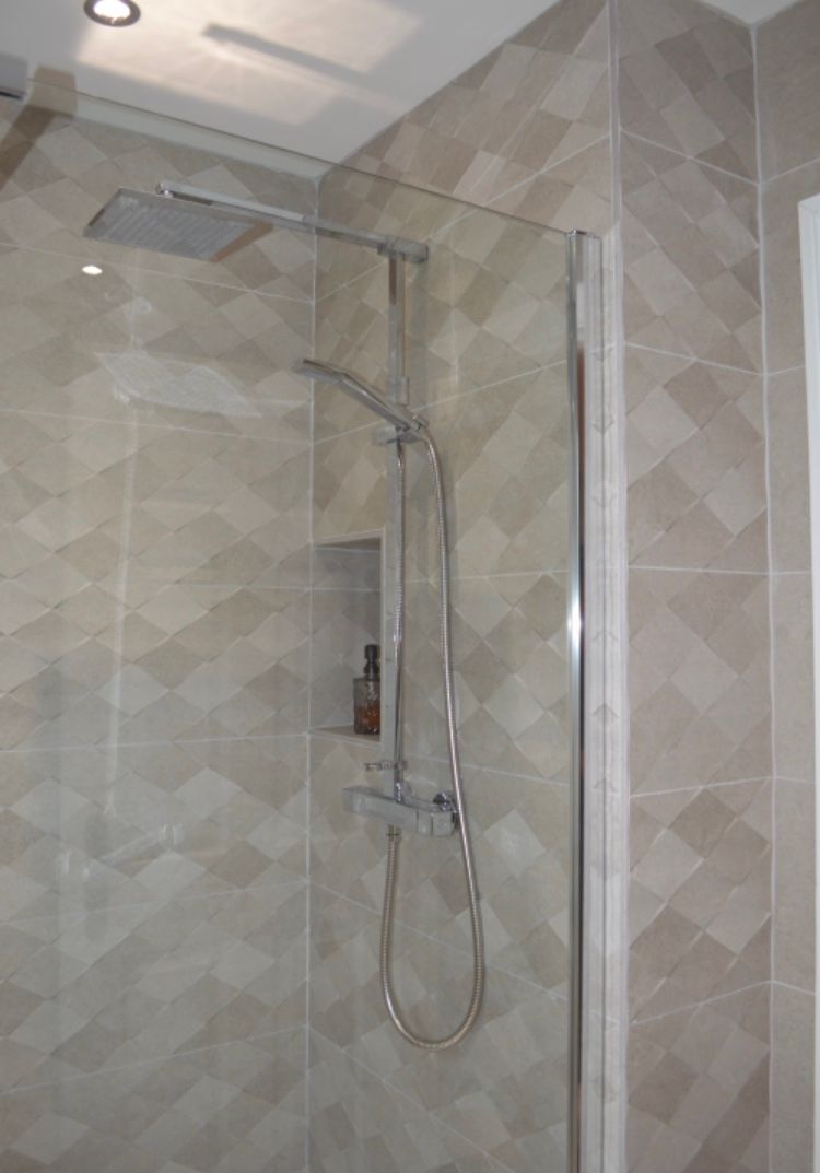 A shower stall with a glass door and a shower head.