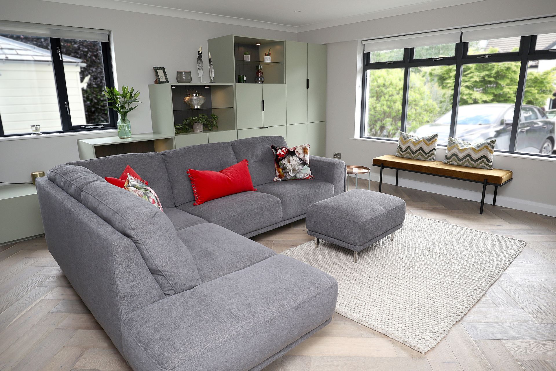 A living room with a large sectional couch and ottoman.