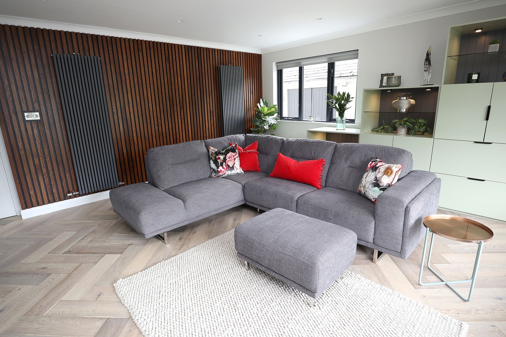 A living room with a large sectional couch and ottoman