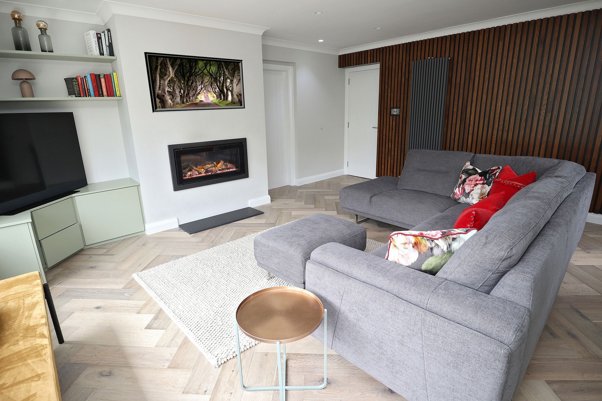 A living room with a couch , fireplace and television.