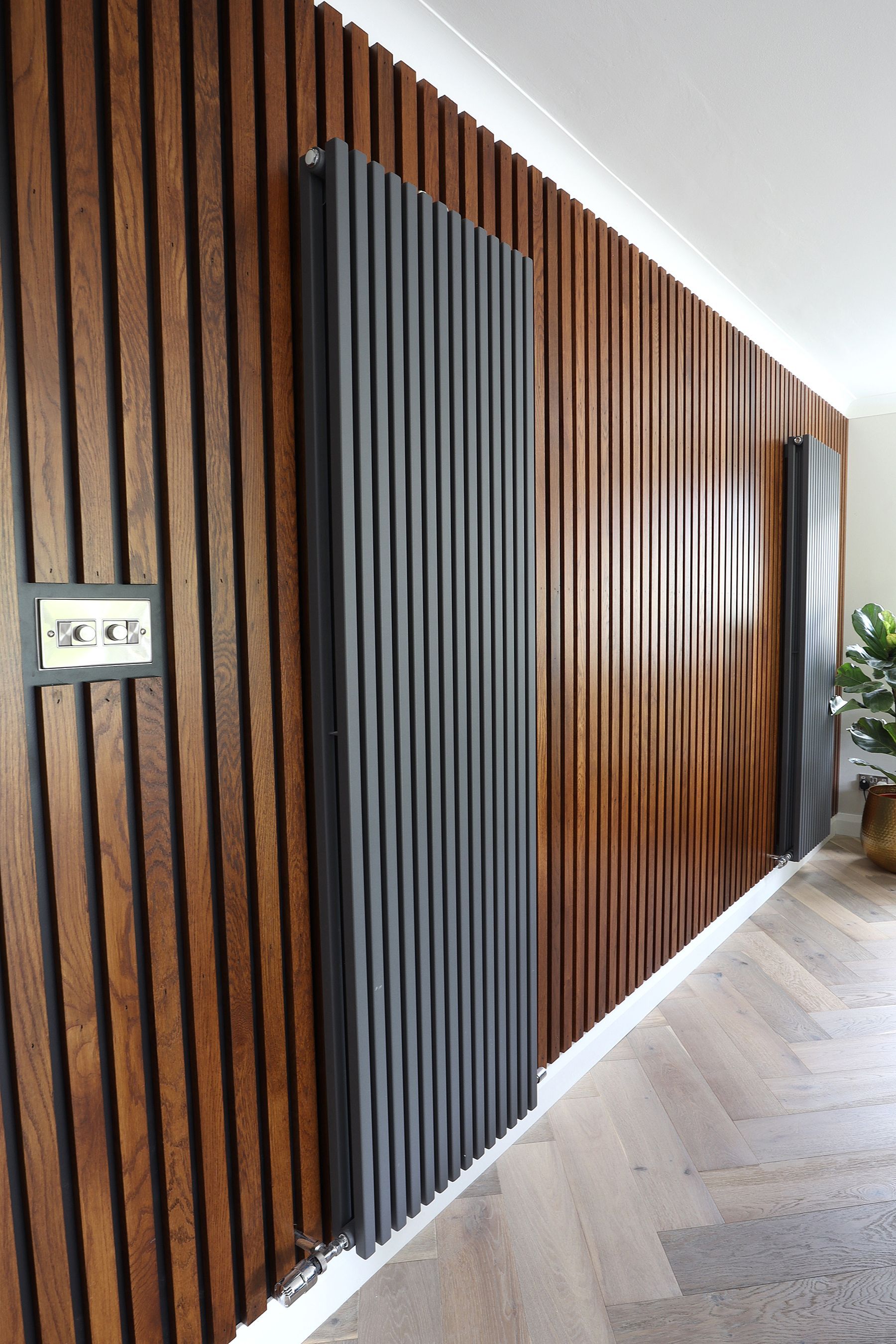 A hallway with wood paneling and a radiator on the wall.