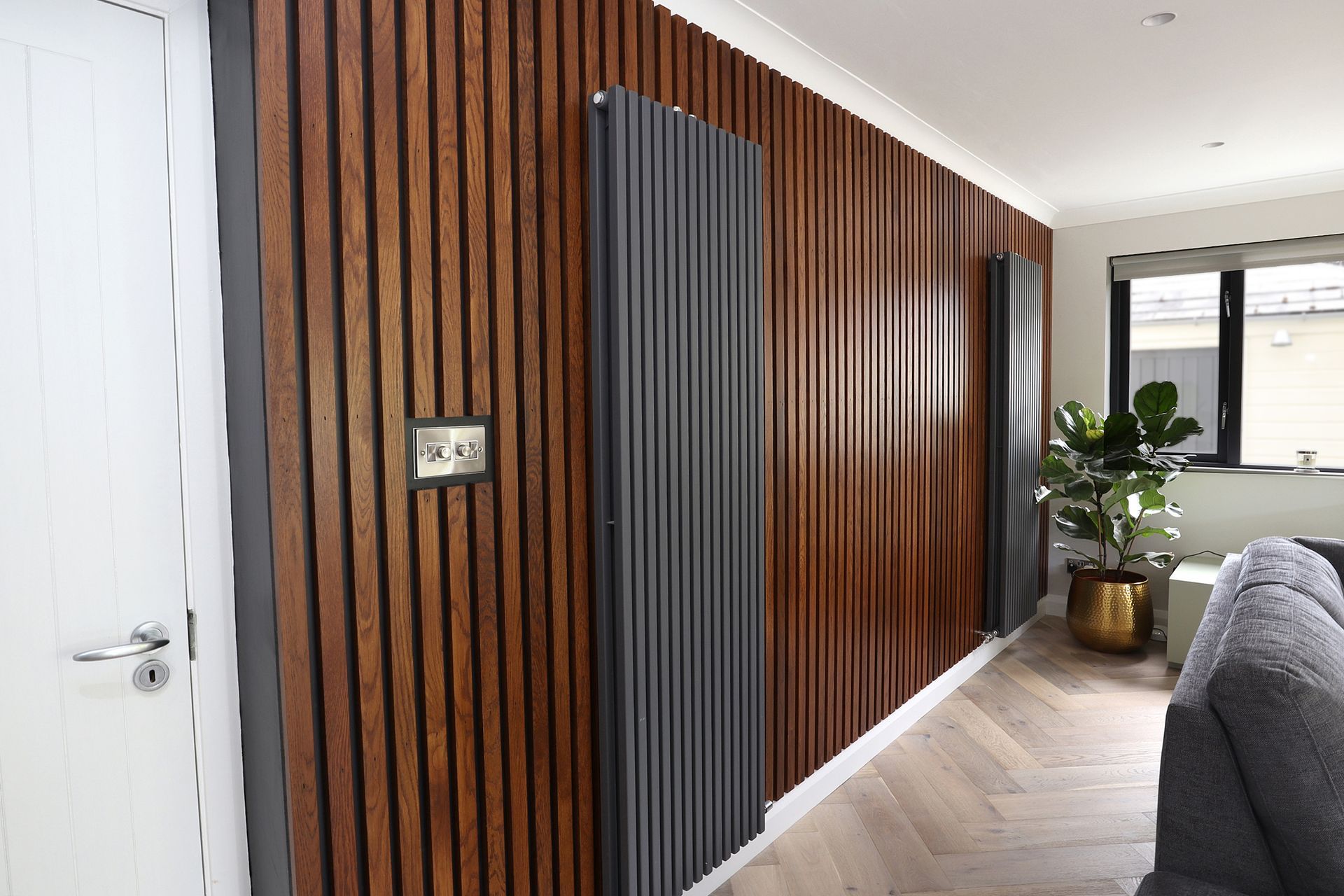 A living room with a wooden wall and a couch.