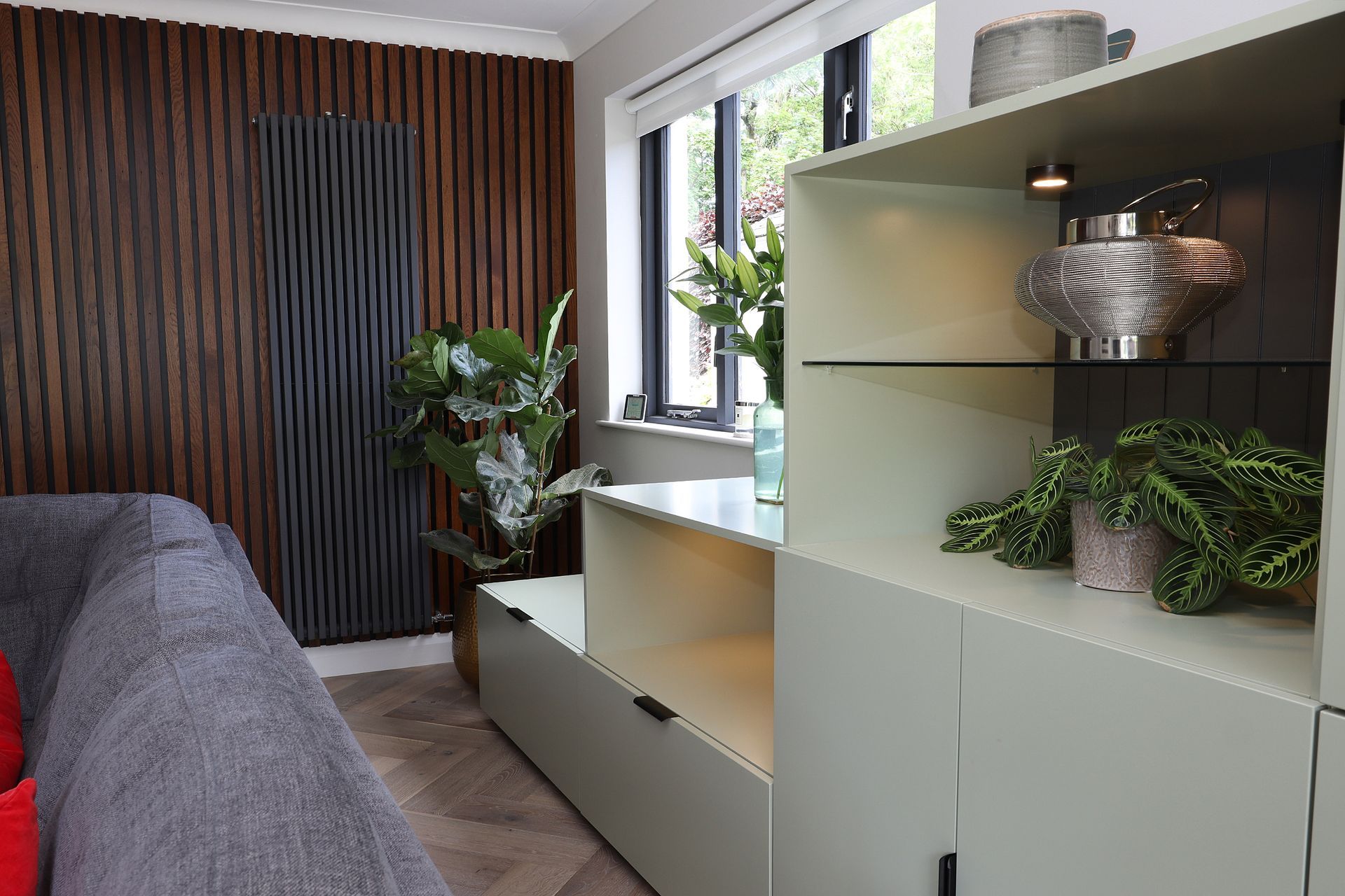 A living room with a couch , shelves , and a window.