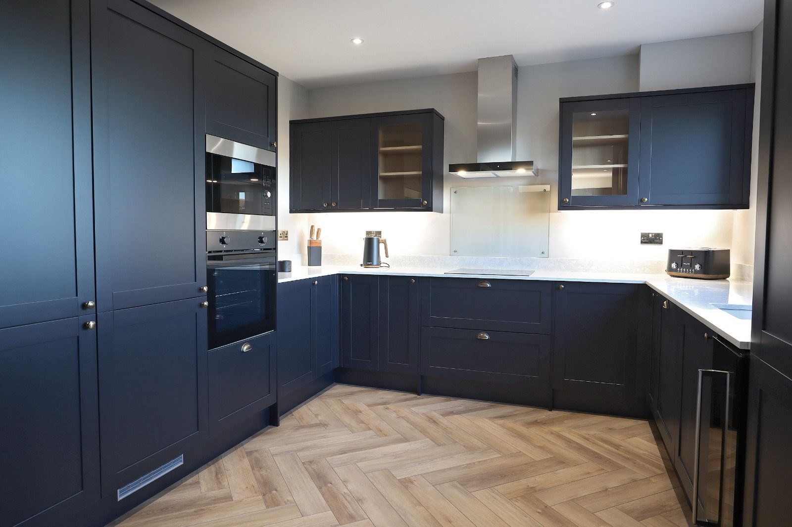 A kitchen with blue cabinets and a black oven.