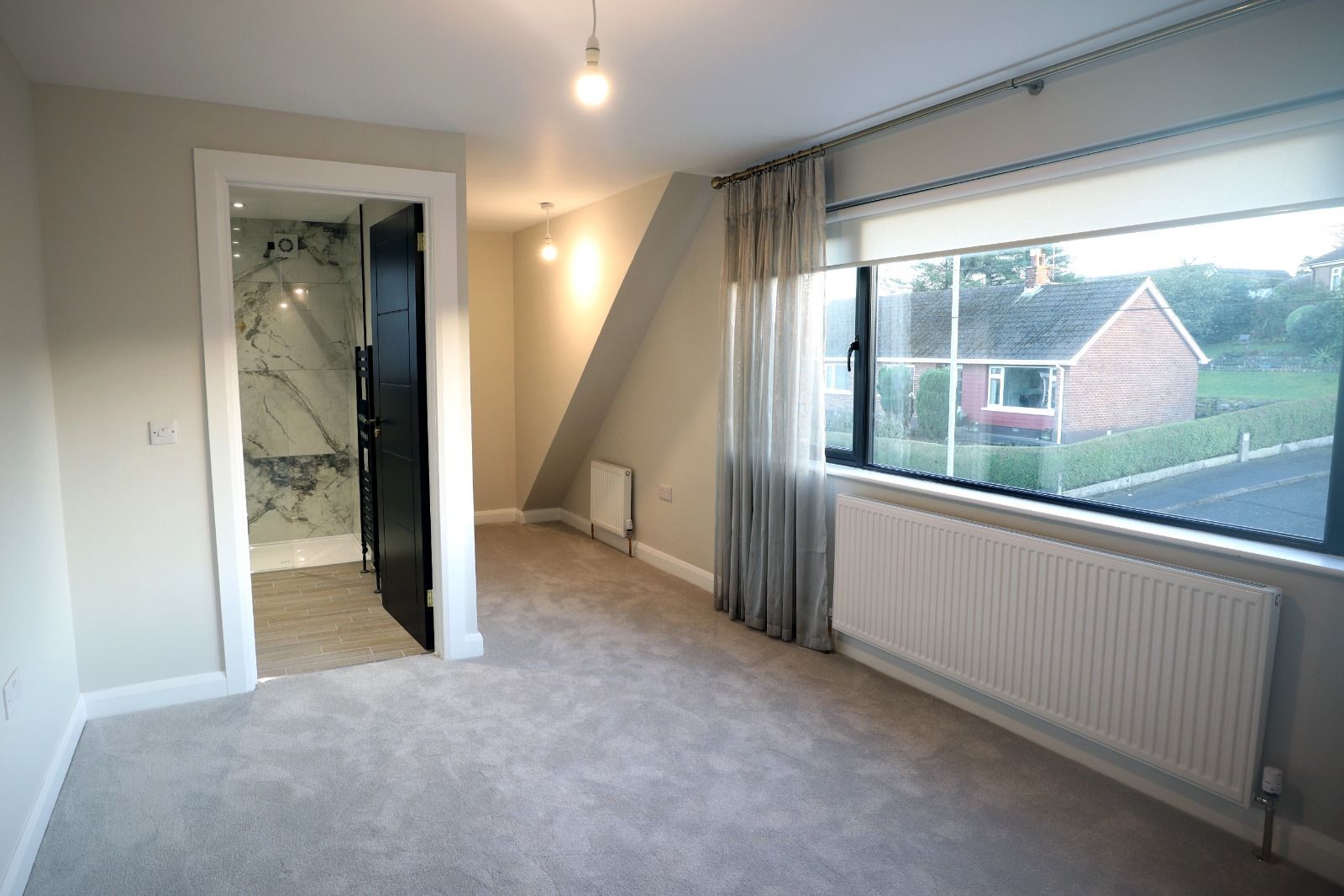 A bedroom with a large bed and a mirror