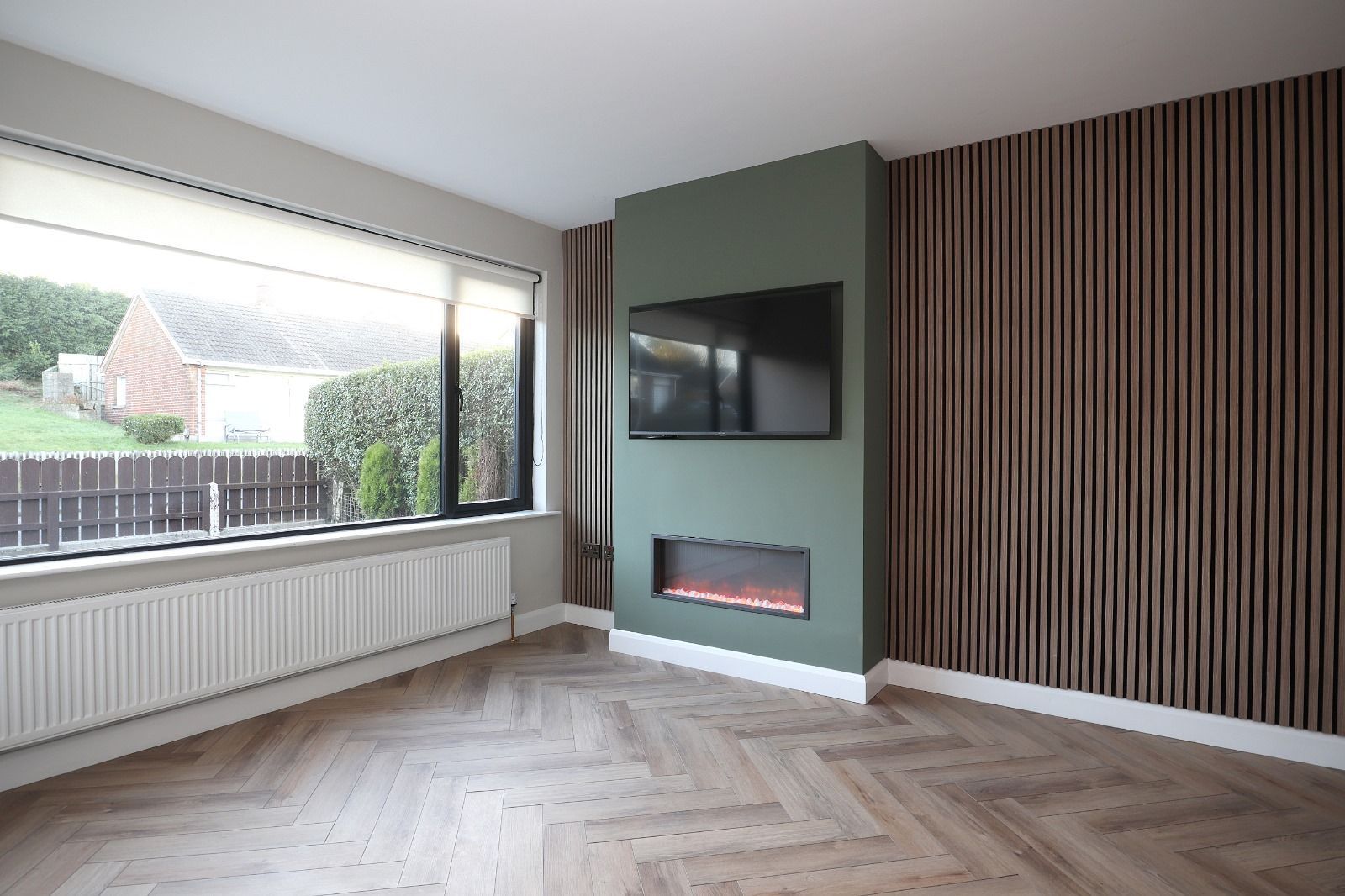 A living room with two purple couches and a purple ottoman.