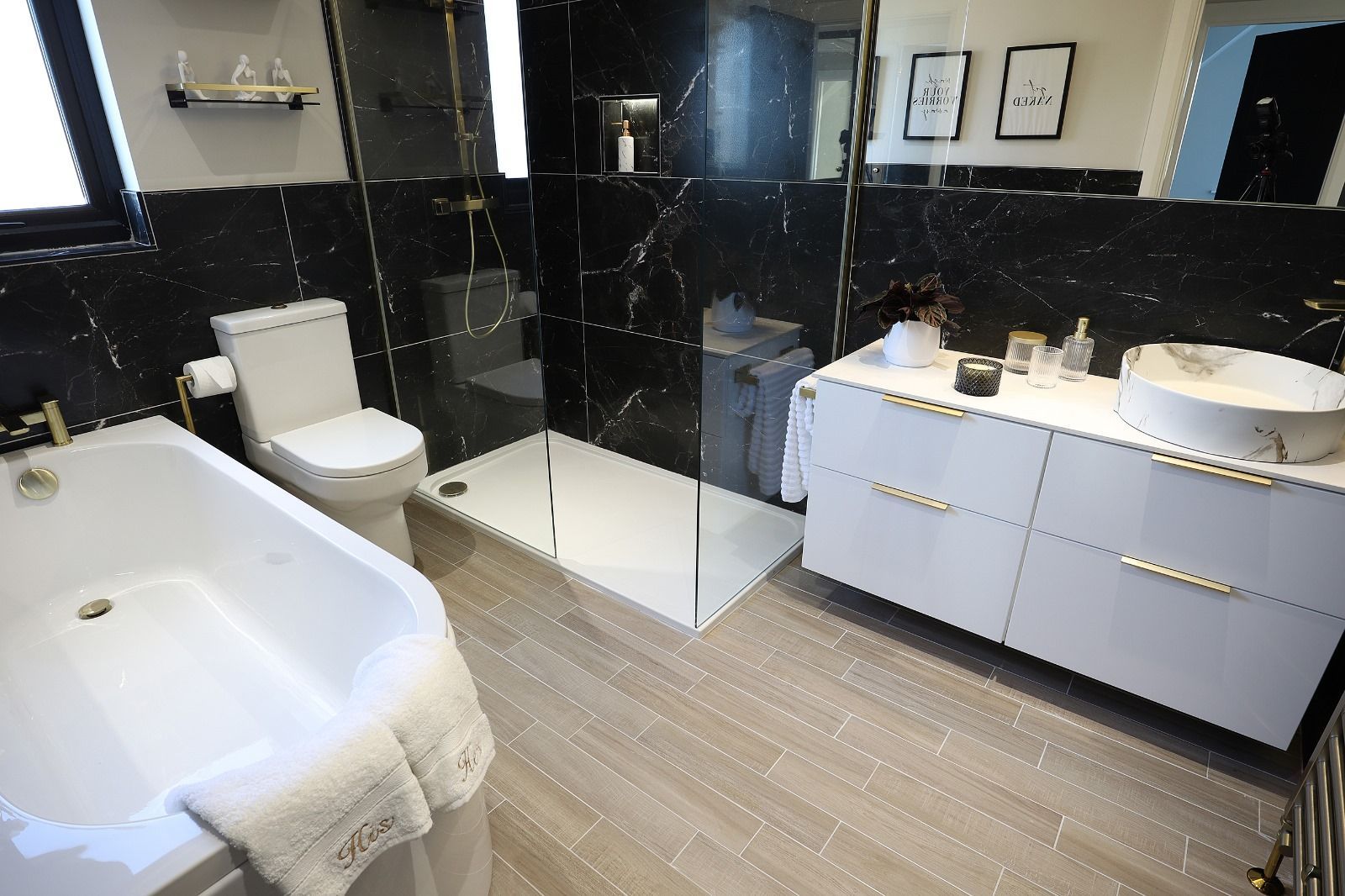 A bathroom with green tiles , a sink , toilet , and bathtub.