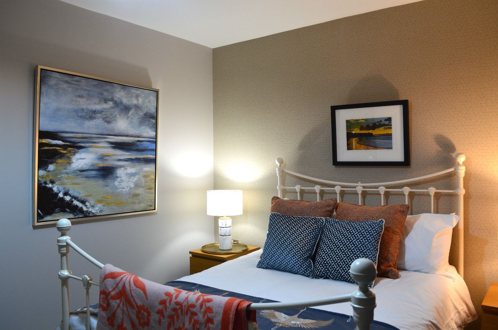 A bedroom with a bed and a painting on the wall above it.