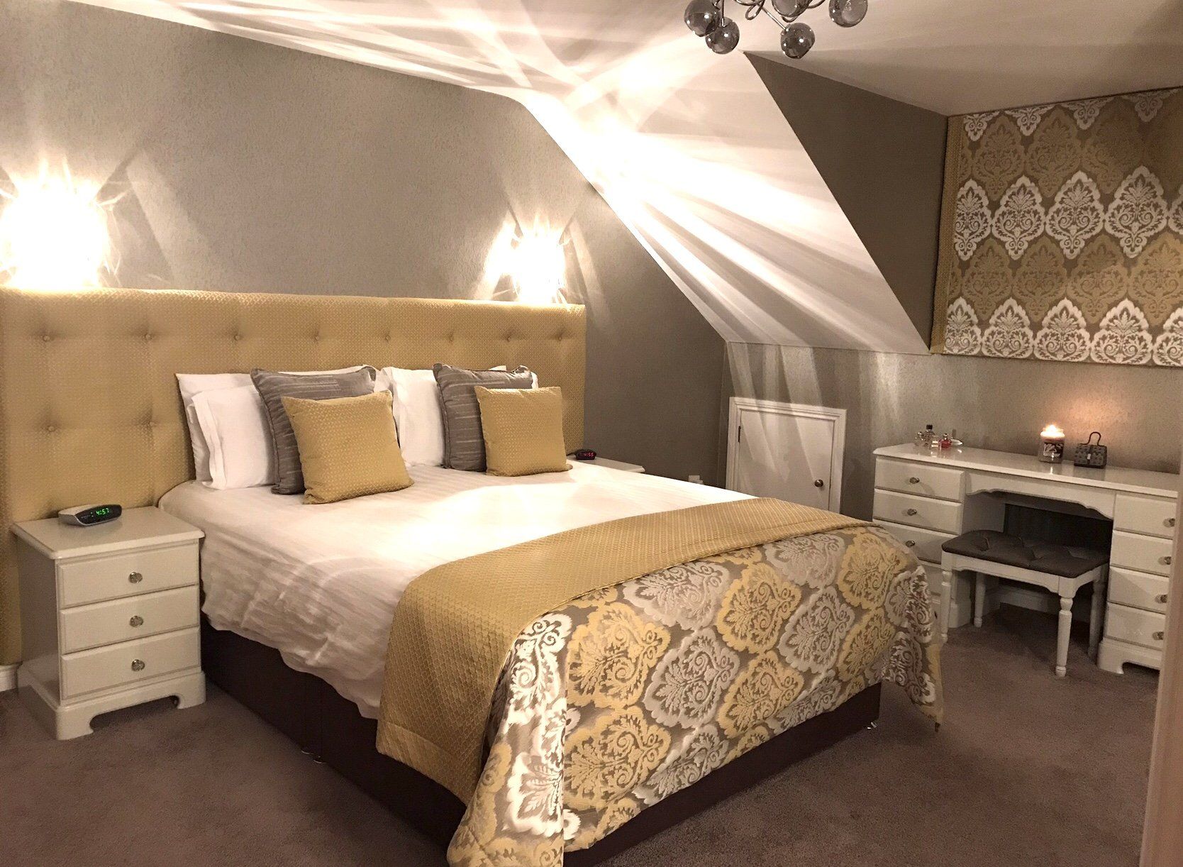 A bedroom with a large bed and a desk