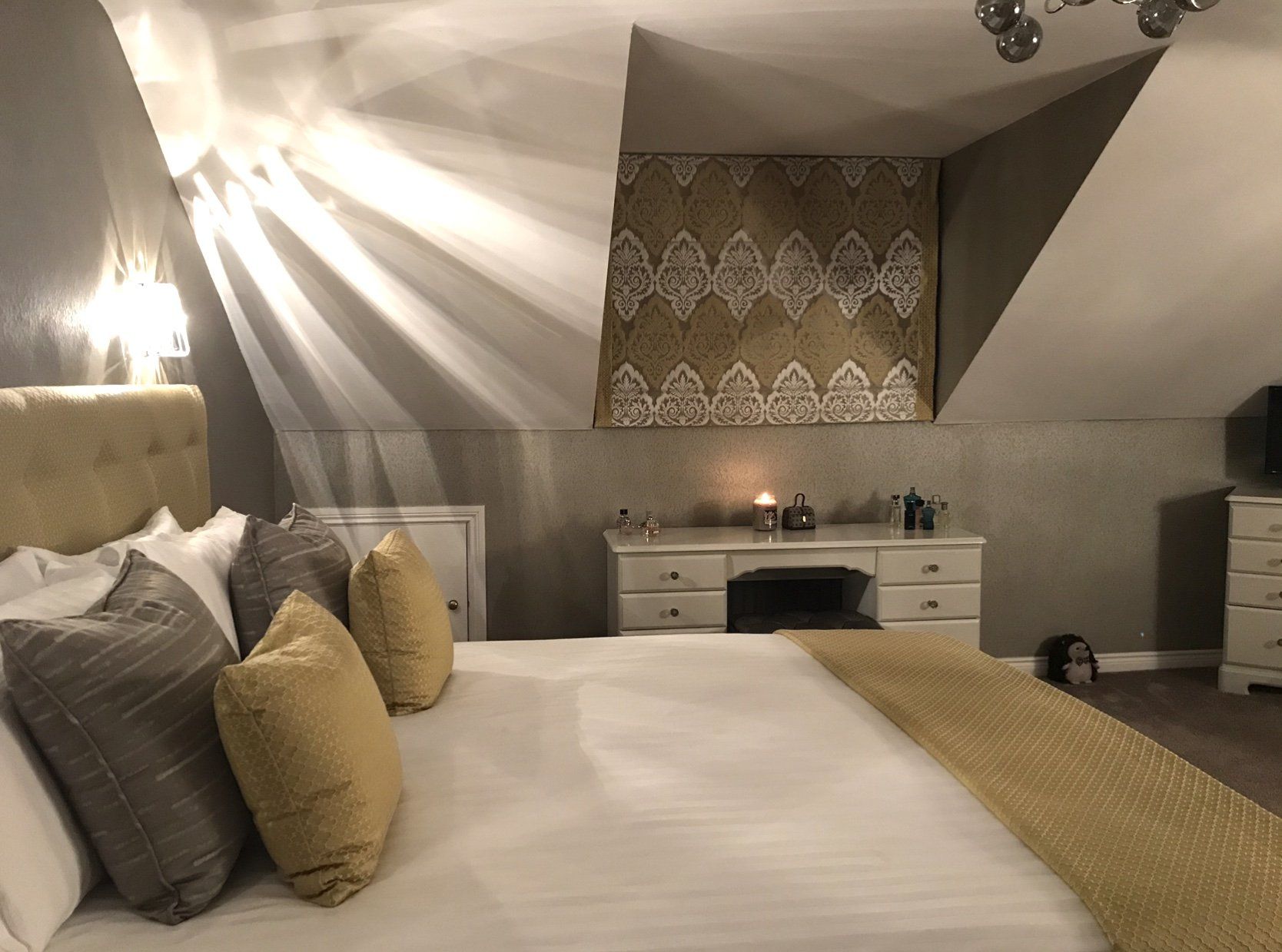 A bedroom with a large bed and a desk