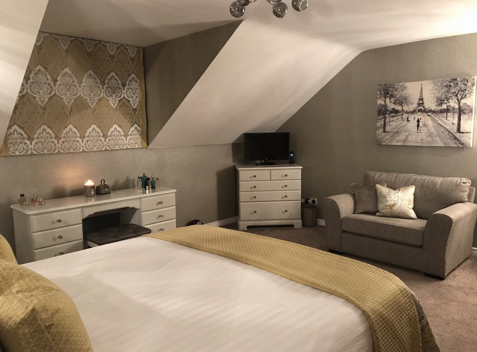 A bedroom with a bed , couch , desk and television.