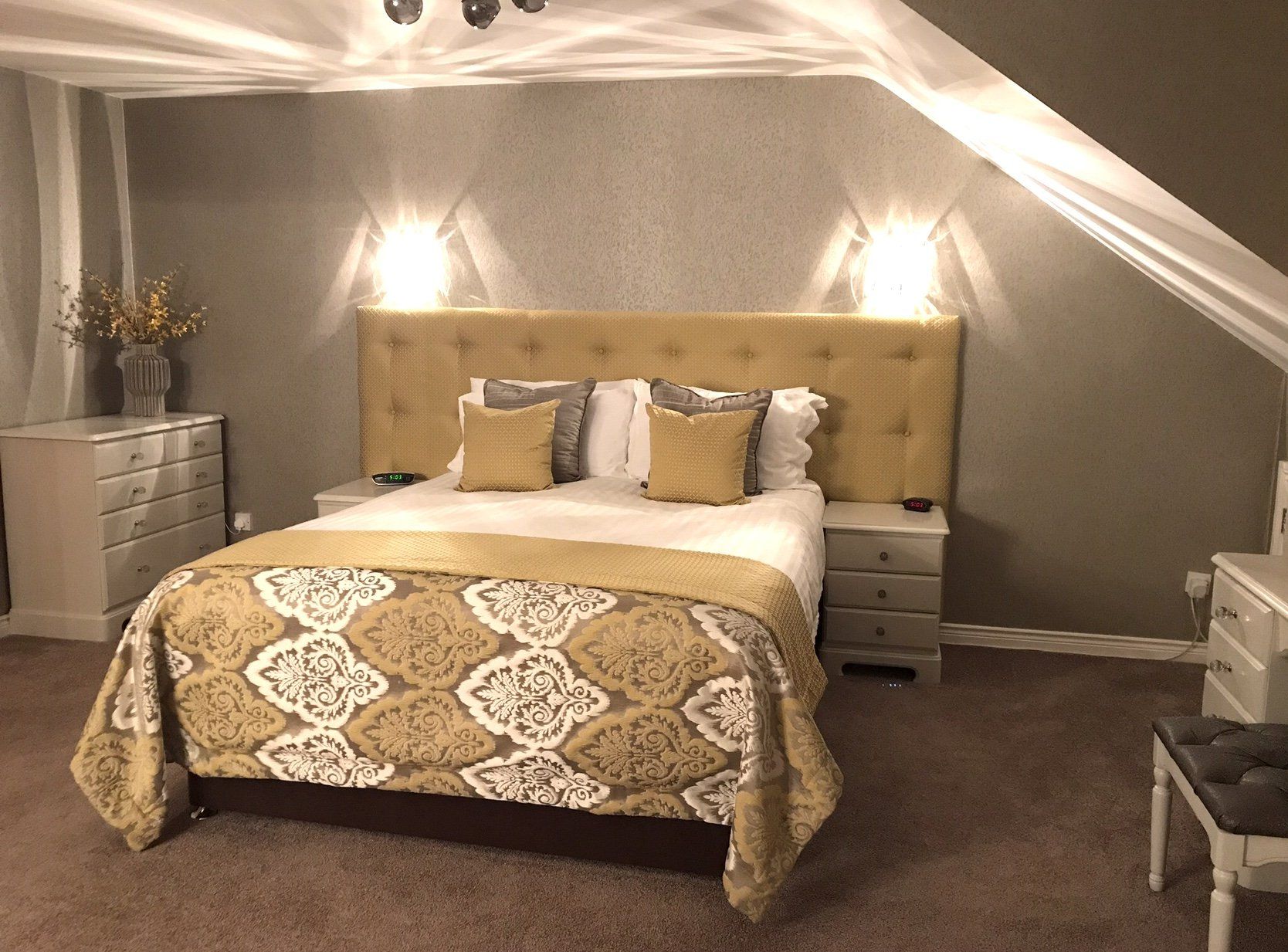 A bedroom with a bed , nightstand , dresser and chair.