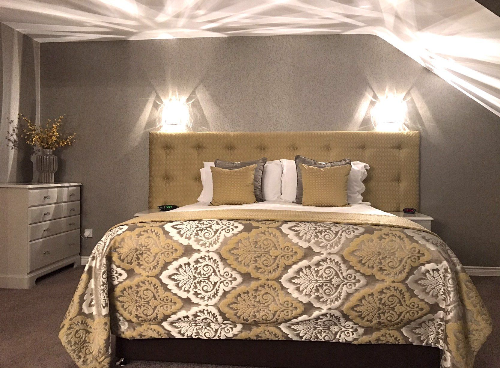 A bedroom with a king size bed and a dresser