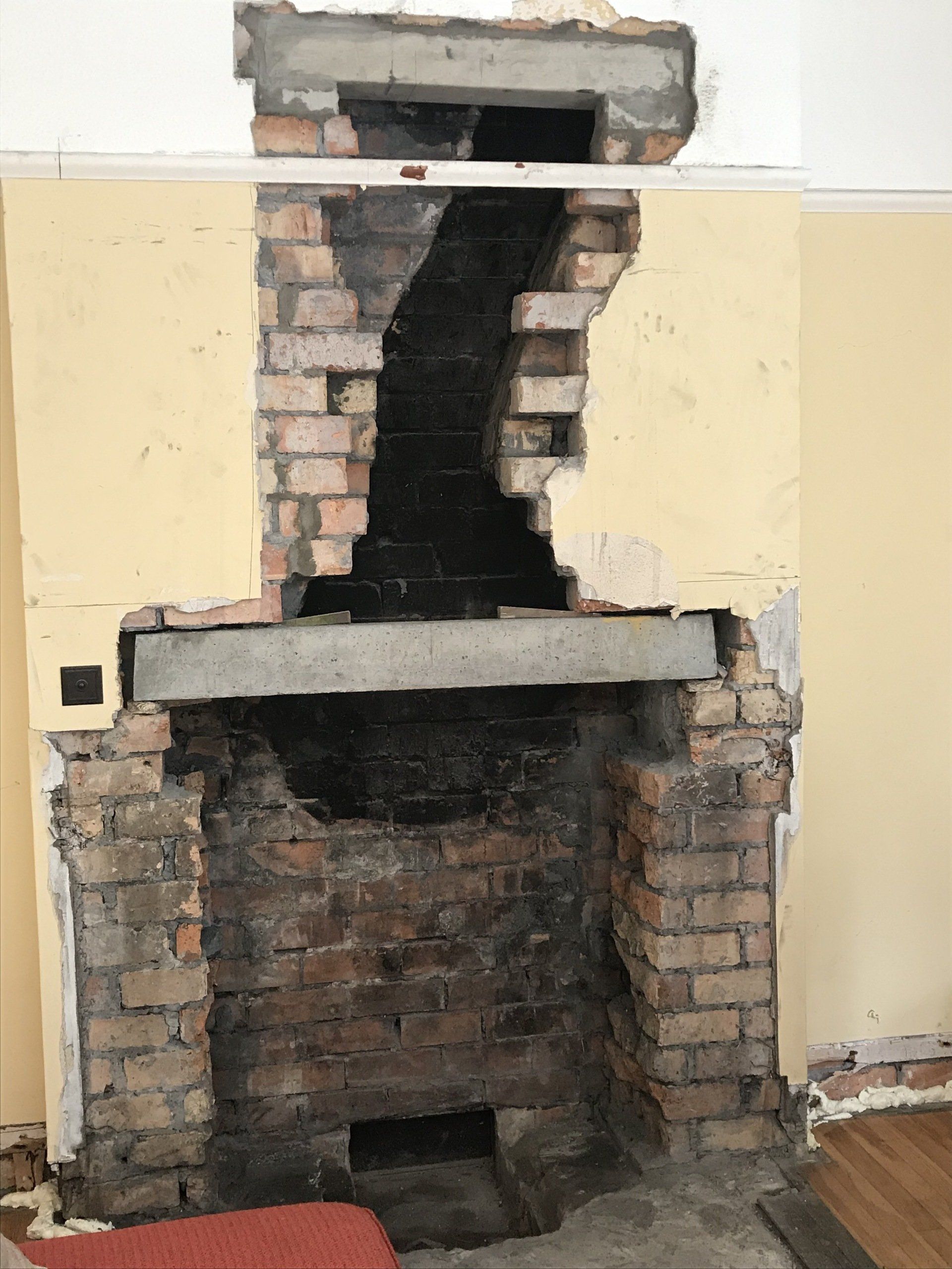 A brick fireplace is being remodeled in a living room.