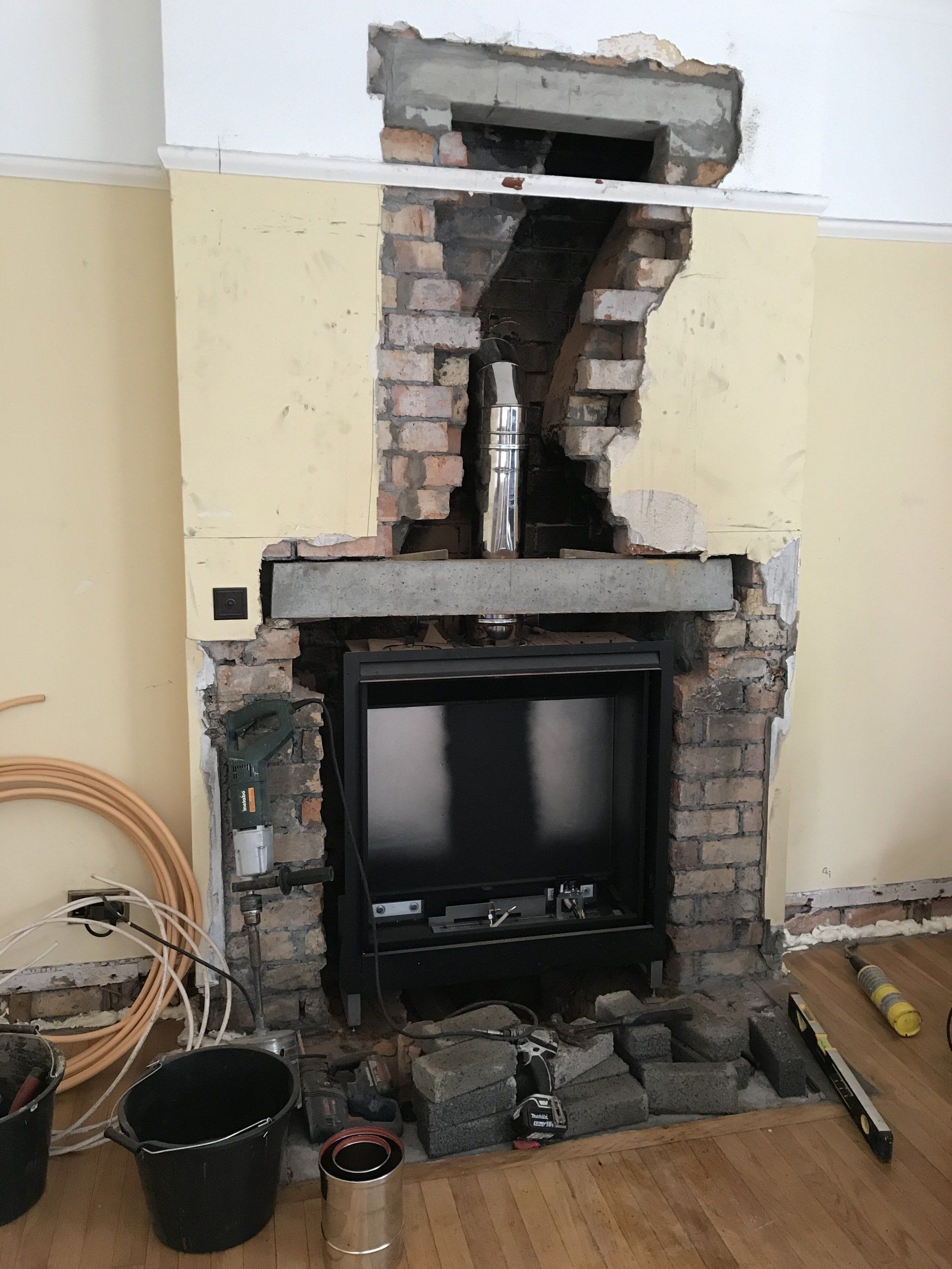 A brick fireplace is being remodeled in a living room.