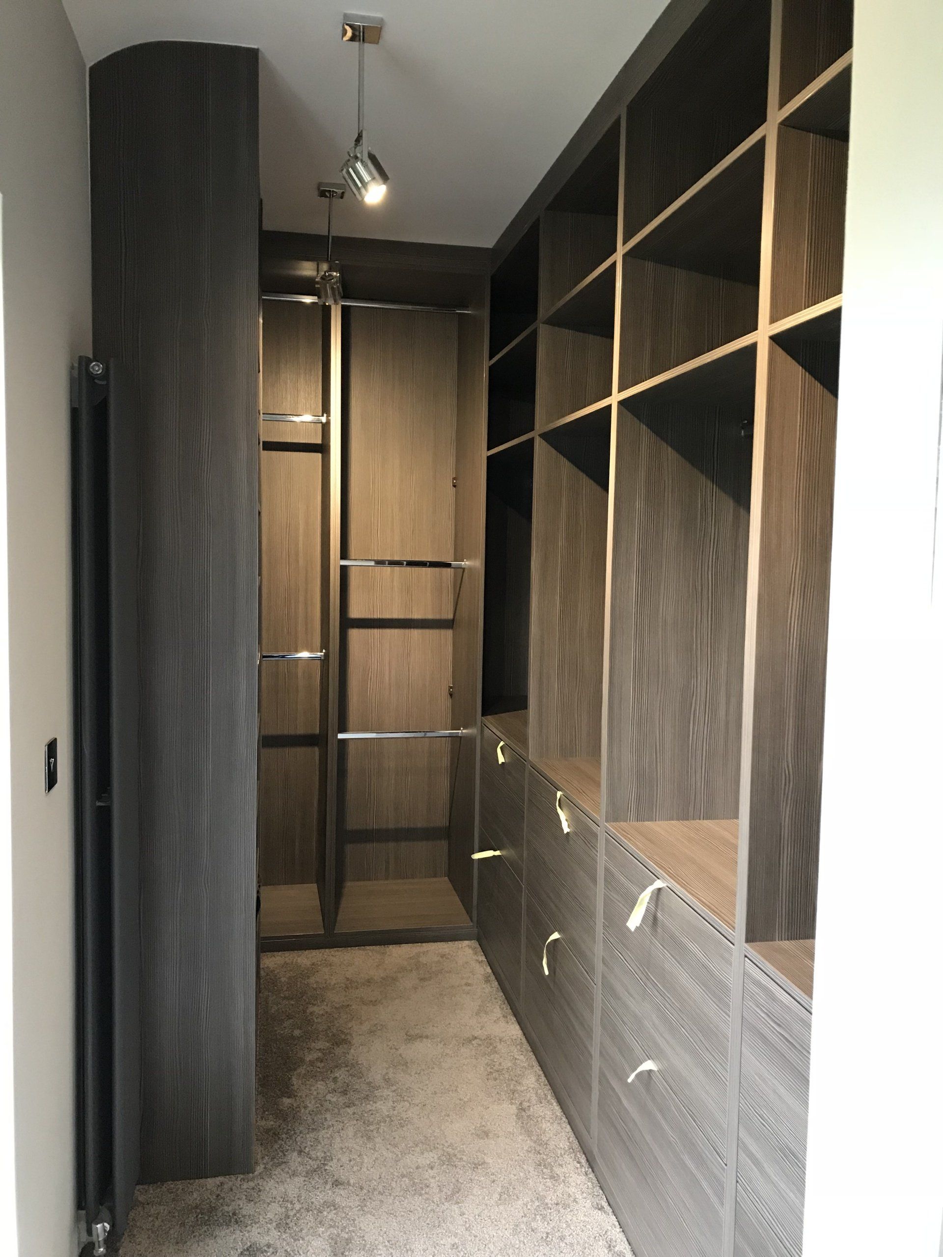 A walk in closet with lots of shelves and drawers