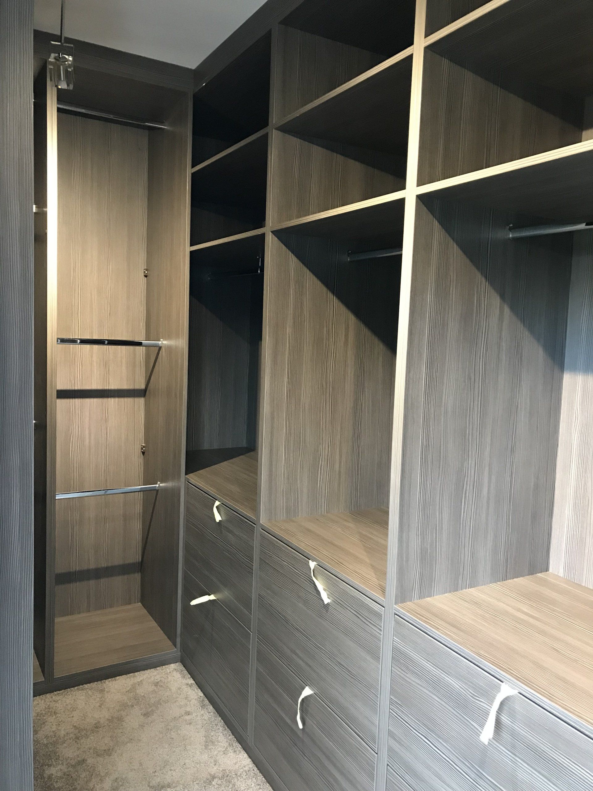 A walk in closet with lots of shelves and drawers.