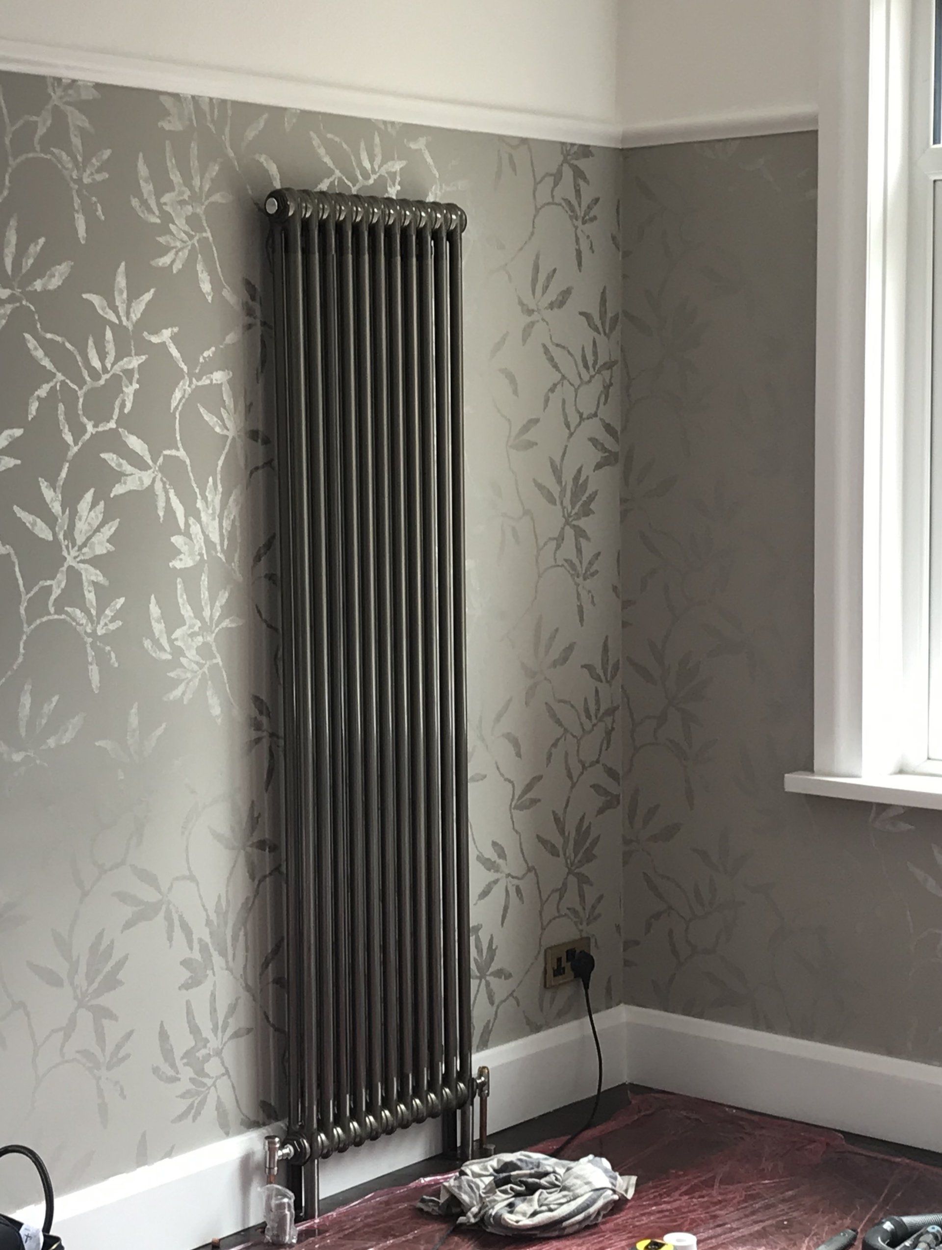 A room with a radiator on the wall and a window.