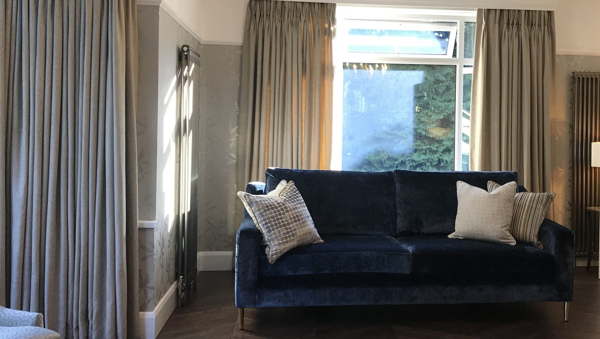 A living room with a blue couch and a window.
