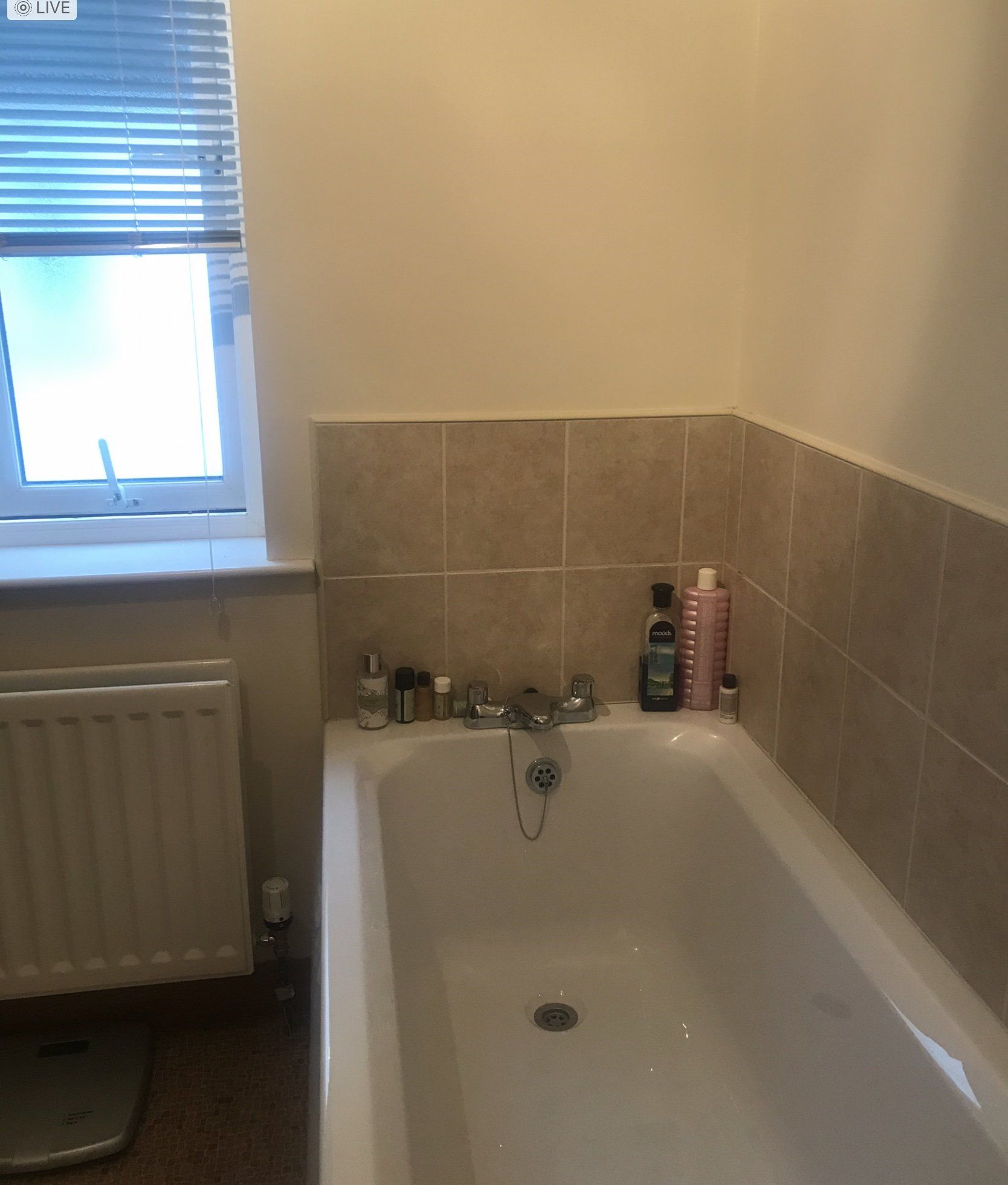 A bathroom with a bathtub and a window