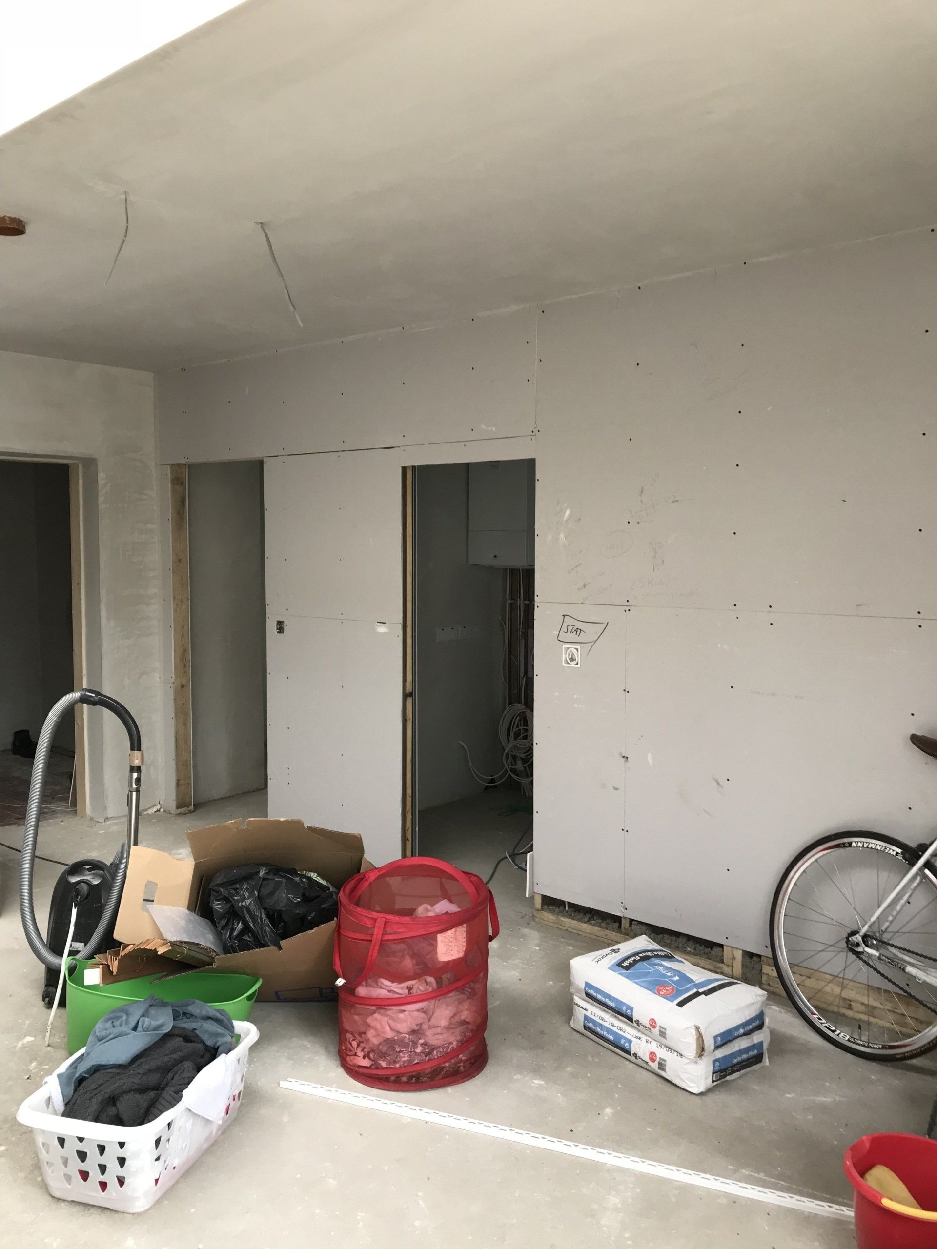 A room with a vacuum cleaner and a bicycle in it.