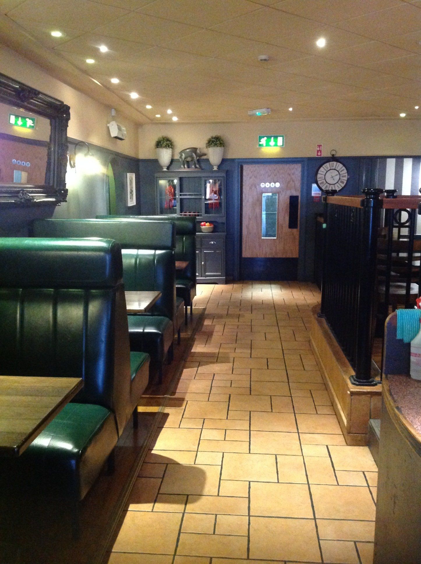 The inside of a restaurant with green booths and tables