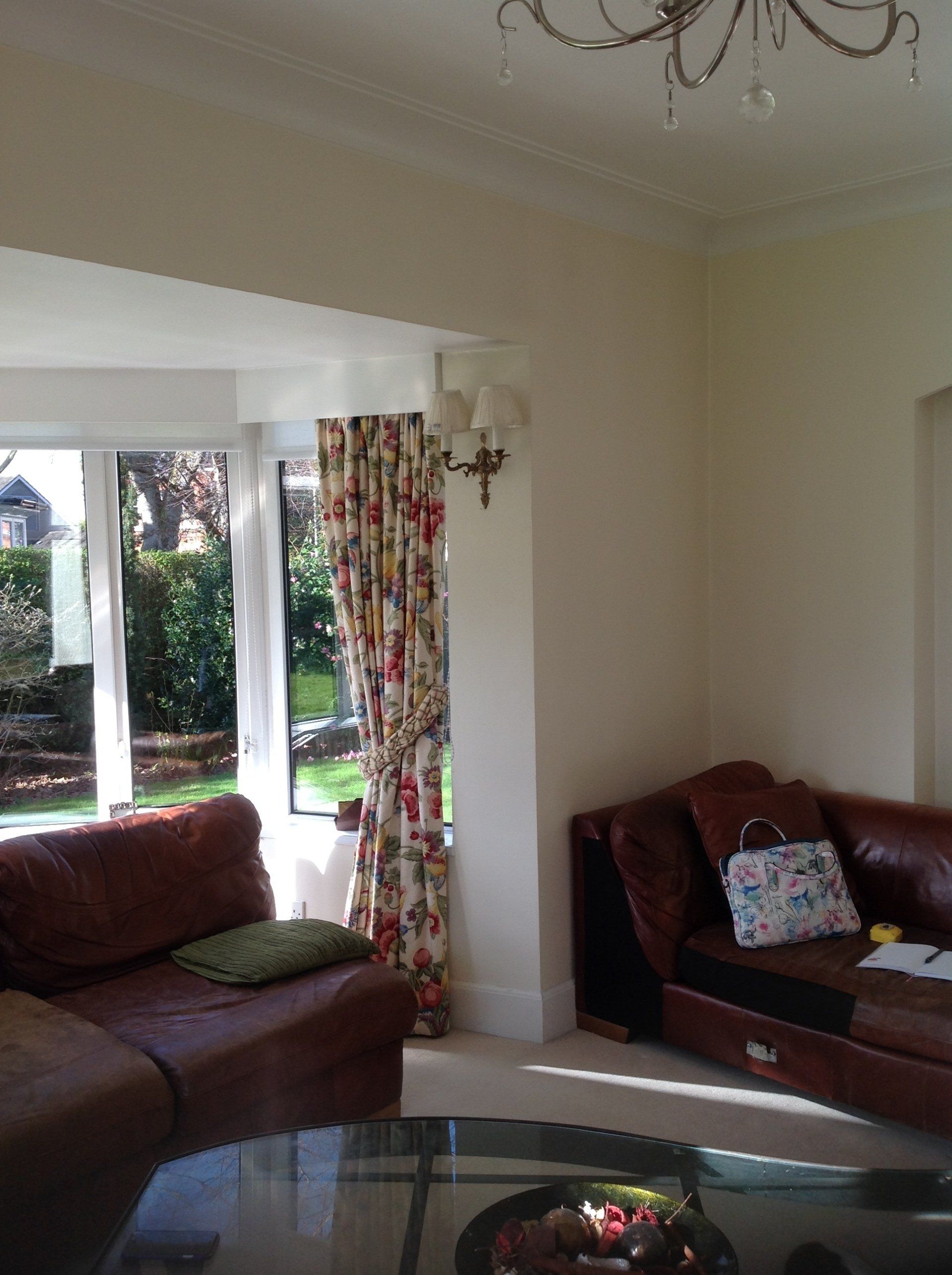 A living room with a brown leather couch and a glass coffee table.