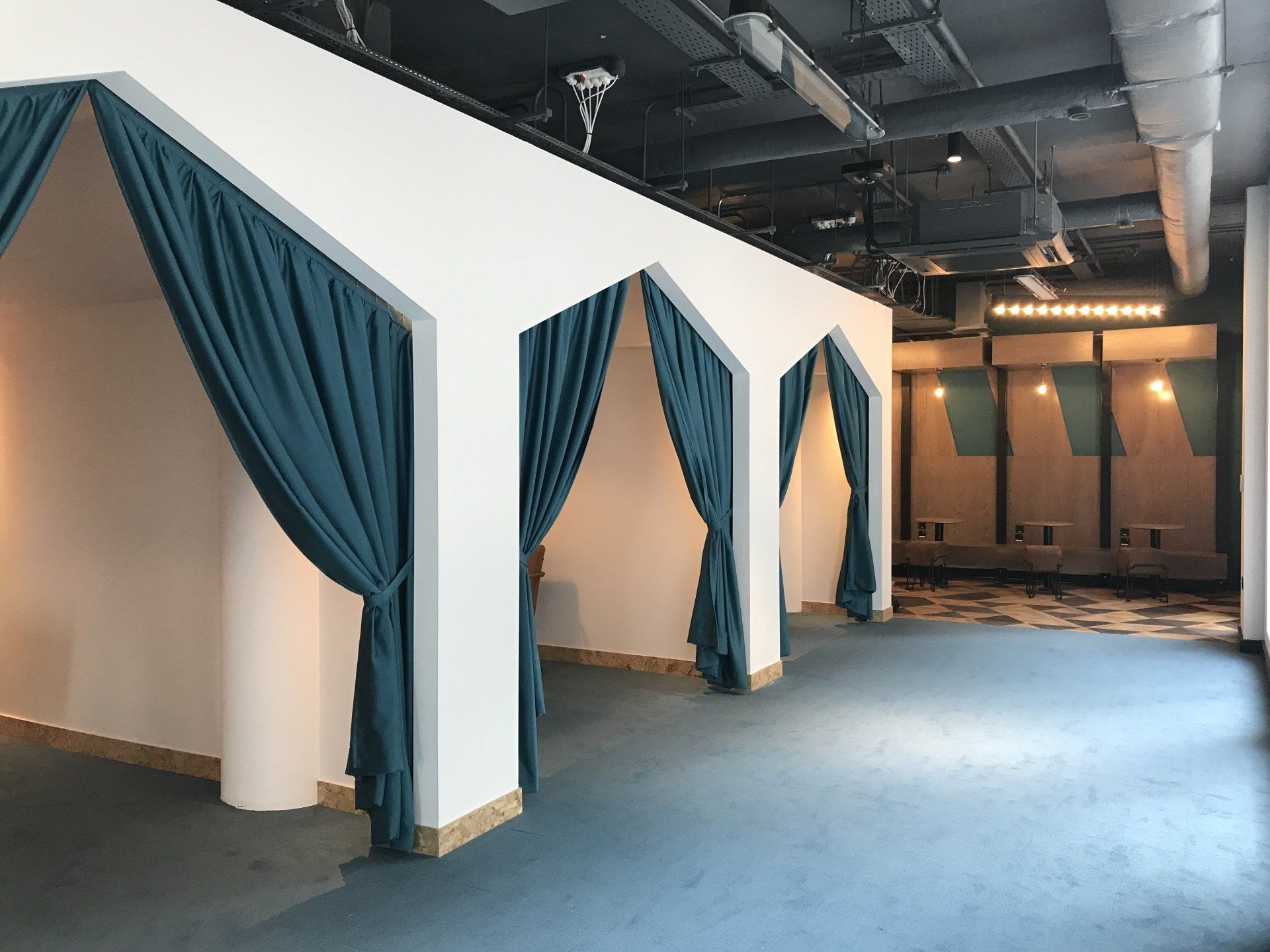 A room with blue curtains on the walls and a blue carpet.