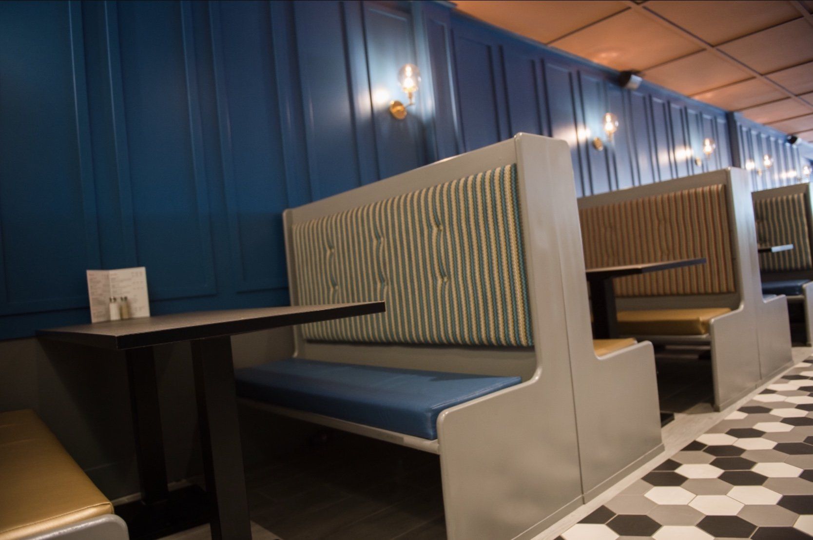 A row of booths with tables in a restaurant.